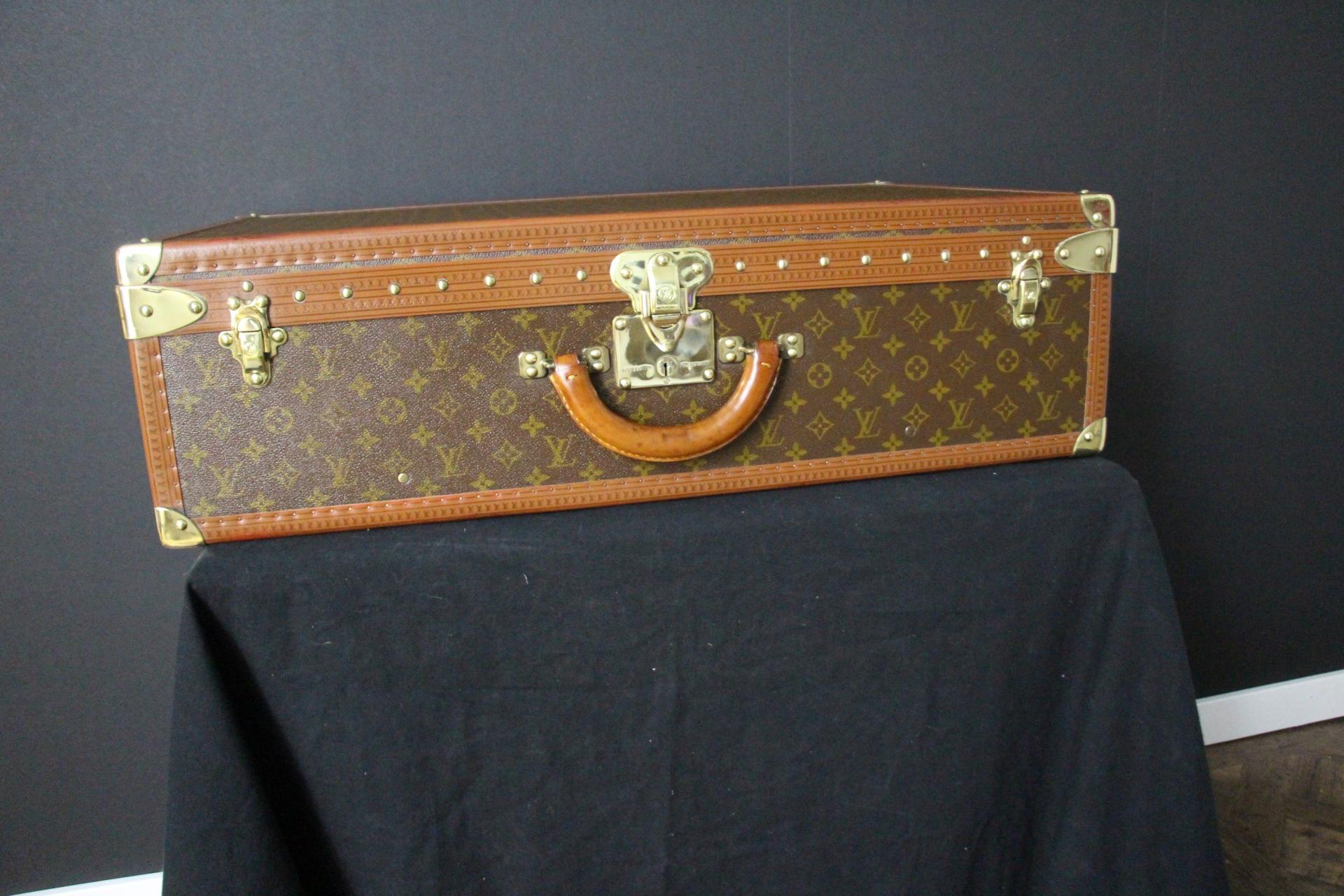 Dieses Gepäckstück ist ein prächtiger Louis Vuitton Alzer Monogramm-Koffer. Dieser 75 cm große Koffer ist fast der größte und sicherlich auch der luxuriöseste Koffer von Louis Vuitton. Sie verfügt über alle Louis Vuitton Beschläge aus massivem