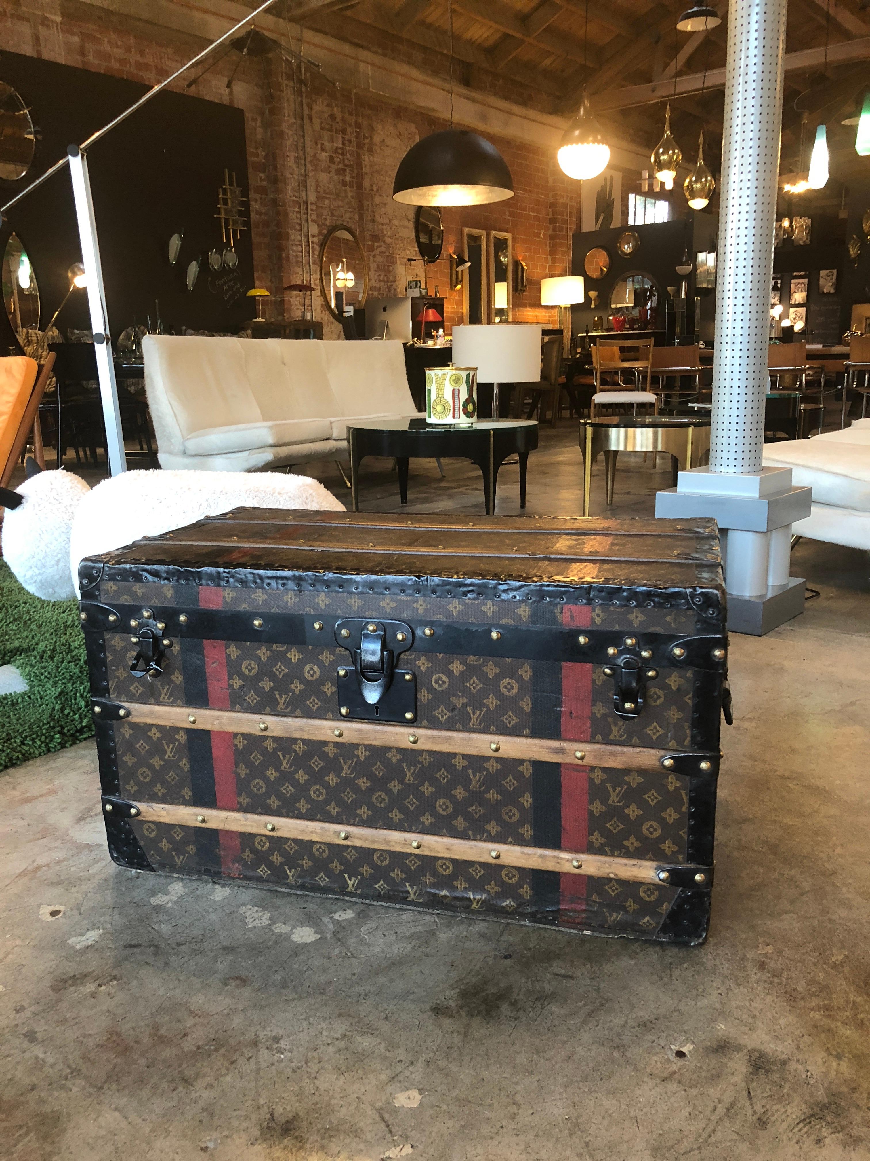 A Louis Vuitton trunk. LV monogram pattern covers the exterior. The interior is fully lined and distinctive quilted fabric with LV embossed ribbon lines the inside of the lid. Initials stenciled on both sides. A majestic piece that would take place
