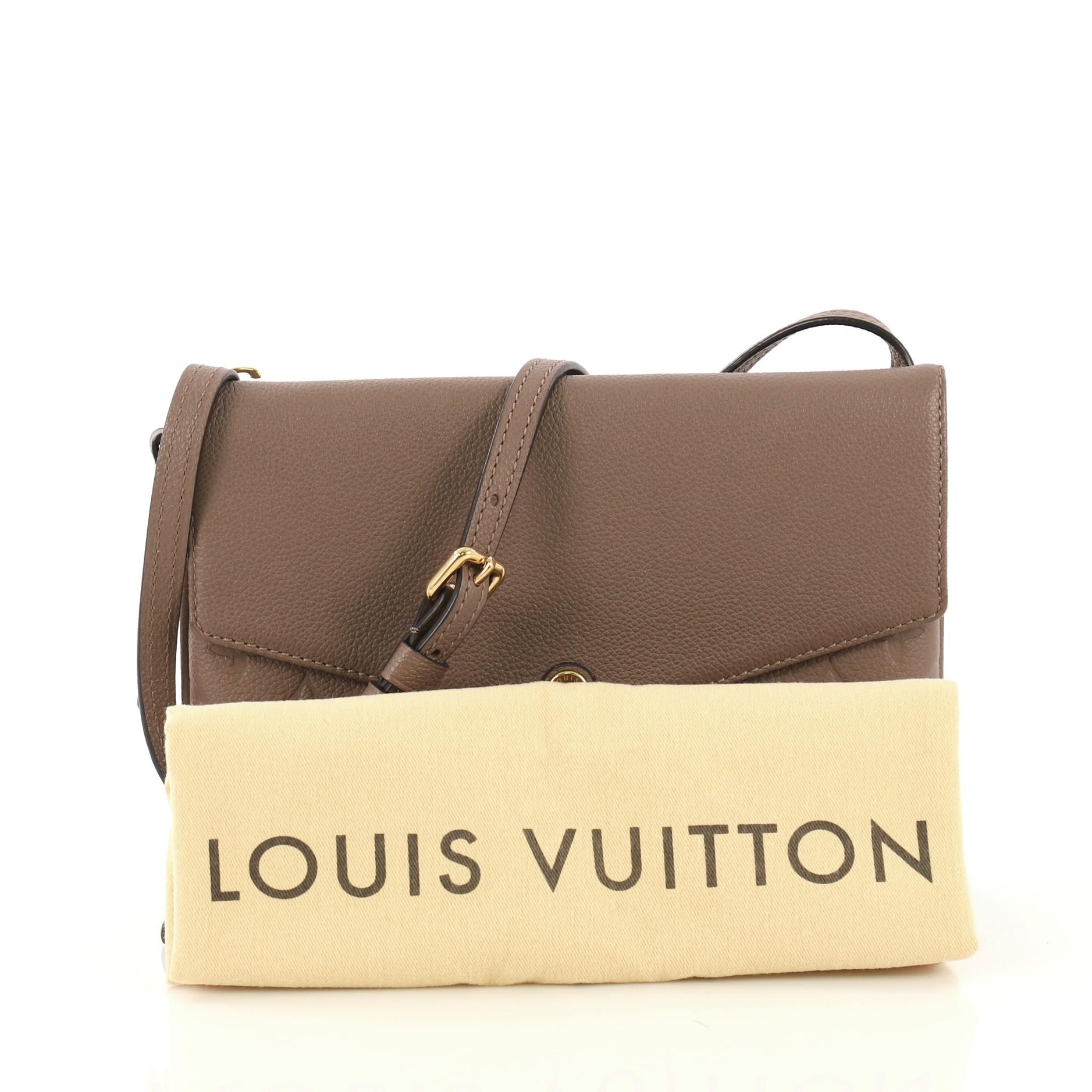 This Louis Vuitton Twice Handbag Monogram Empreinte Leather, crafted in tauped monogram empreinte leather, features an adjustable shoulder strap and gold-tone hardware. Its zip and flap compartments open to a taupe microfiber interior. Authenticity