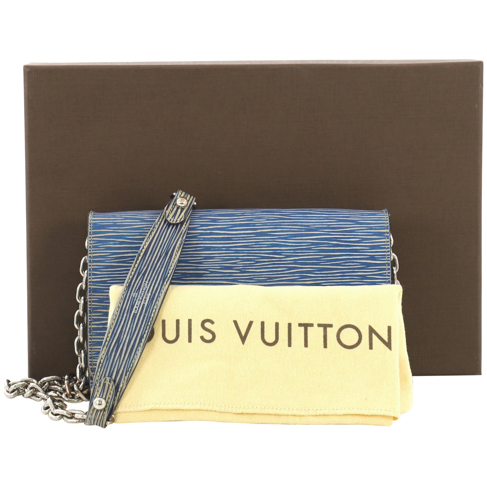 This Louis Vuitton Twist Chain Wallet Epi Leather, crafted from blue epi leather, features a shoulder chain strap and gold-tone hardware. Its flap with twist lock closure opens to a beige leather interior with a zip pocket and multiple card slots.