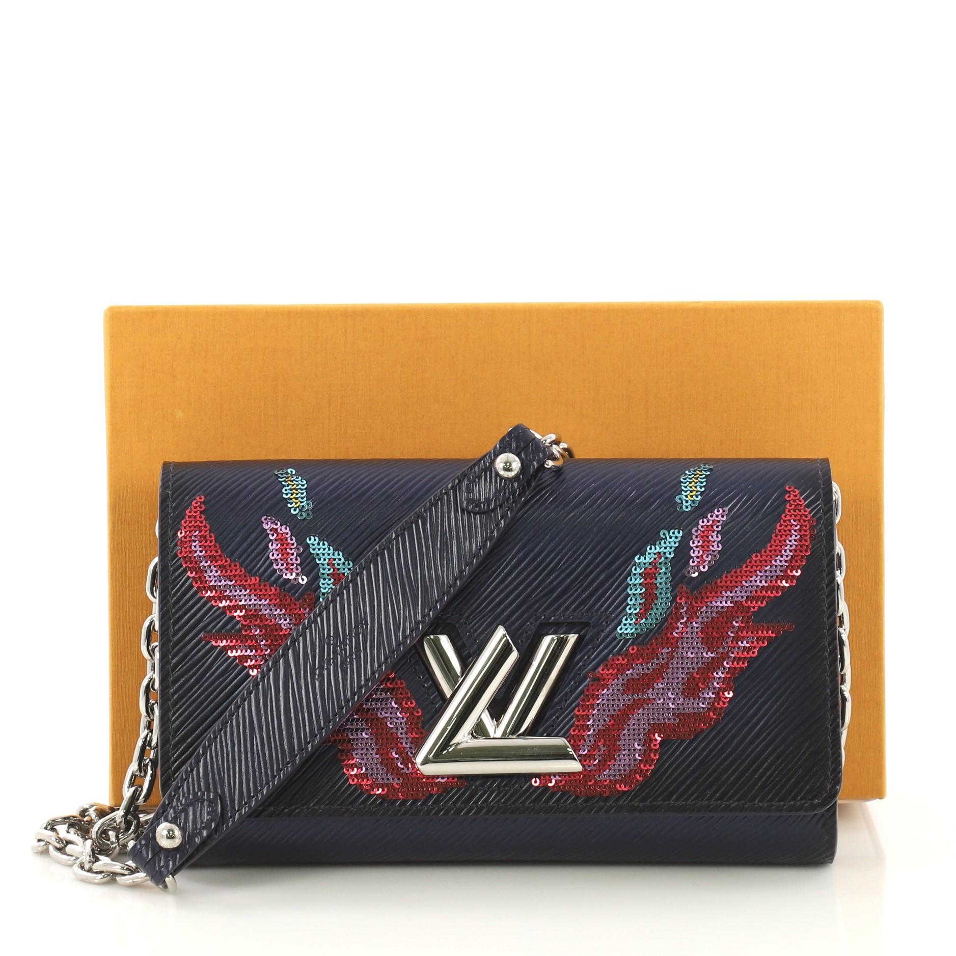This Louis Vuitton Twist Chain Wallet Epi Leather with Sequins, crafted in blue epi leather, features sequin-embroidered flame motif, chain strap with leather pad, and silver-tone hardware. Its LV twist-lock closure opens to a blue leather interior