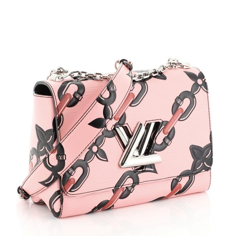 This Louis Vuitton Twist Handbag Chain Flower Print Epi Leather MM, crafted in pink printed epi leather, features a waved base silhouette, chain link strap with leather pad, and silver-tone hardware. Its LV twist lock closure opens to a black