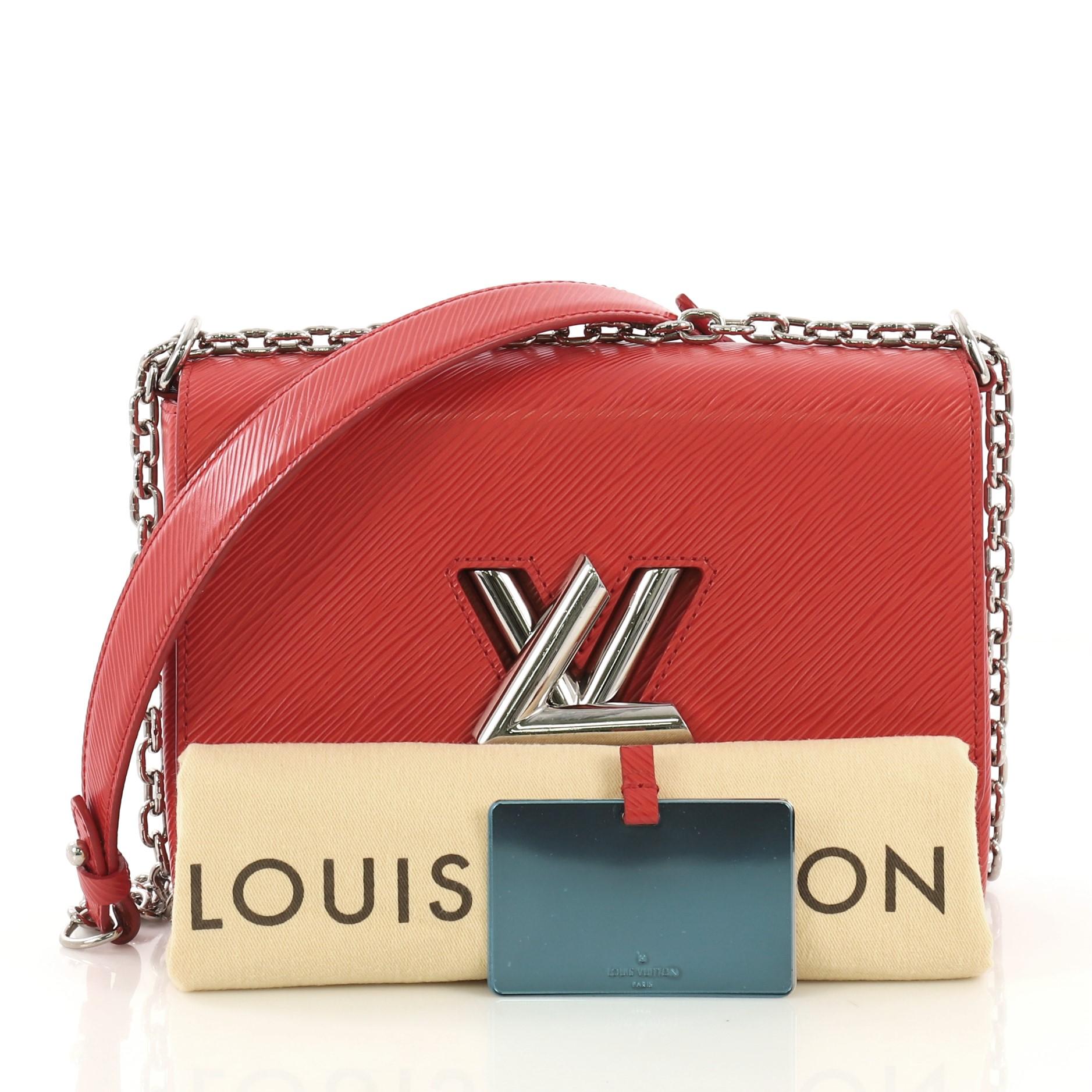 This Louis Vuitton Twist Handbag Epi Leather MM, crafted from red epi leather, features chain link strap with leather pad, frontal flap, and silver-tone hardware. Its LV twist lock closure opens to a light purple microfiber interior with slip