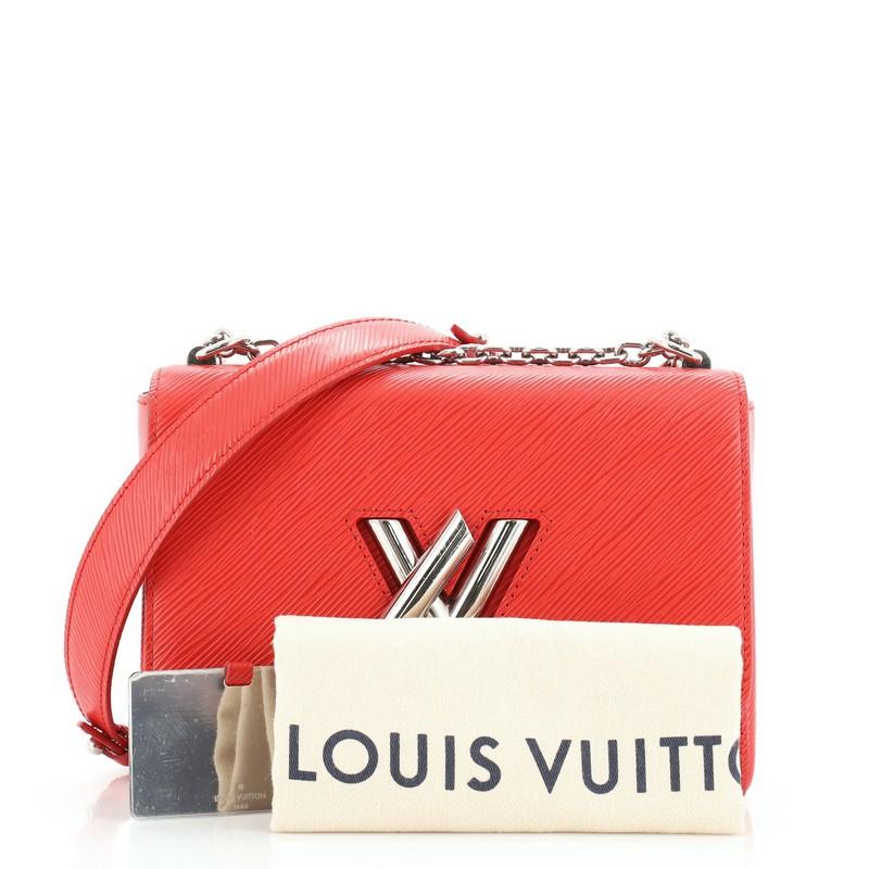 This Louis Vuitton Twist Handbag Epi Leather MM, crafted from red epi leather, features chain link strap with leather pad, frontal flap, and silver-tone hardware. Its LV twist lock closure opens to a pink microfiber interior with slip pockets.