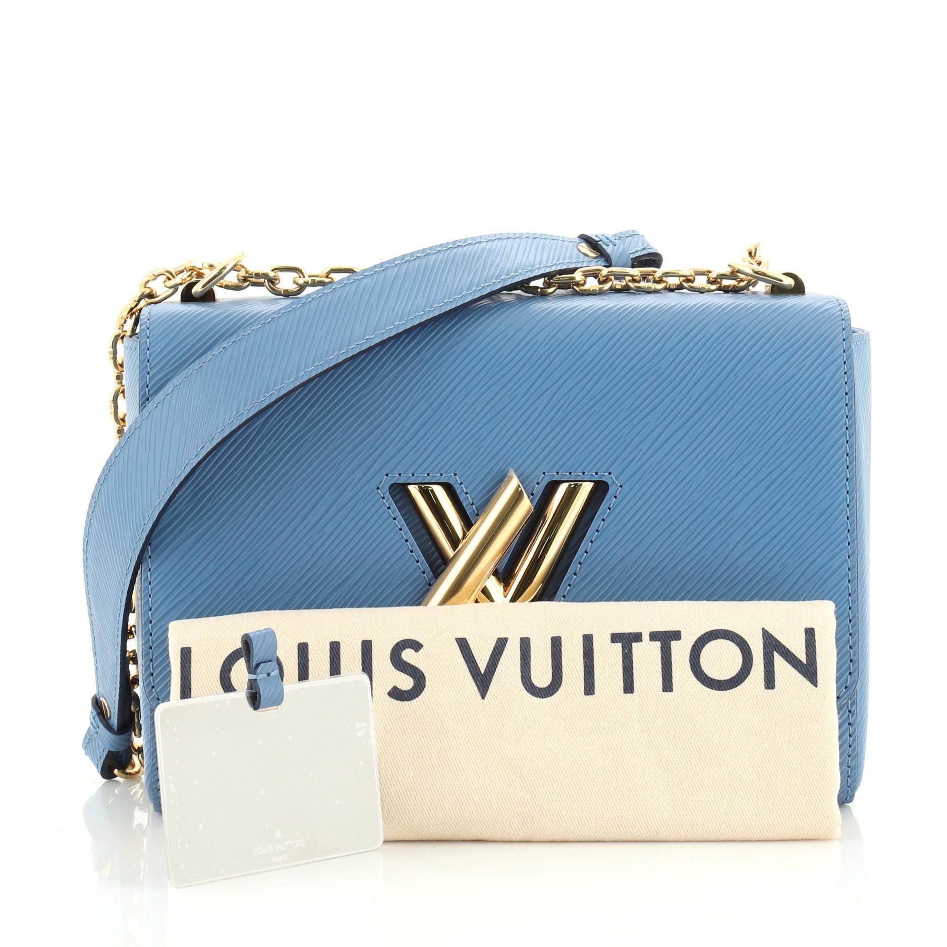 This Louis Vuitton Twist Handbag Epi Leather MM, crafted from blue epi leather, features chain link strap with leather pad, frontal flap, and gold-tone hardware. Its LV twist lock closure opens to a blue microfiber interior with slip pockets.