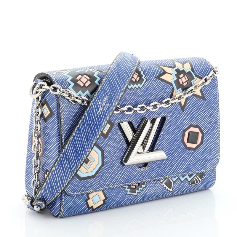 This Louis Vuitton Twist Handbag Limited Edition Azteque Epi Leather MM, crafted from blue azteque epi leather, features long chain strap with leather pad and silver-tone hardware. Its flap with twist-lock closure opens to a neutral microfiber and