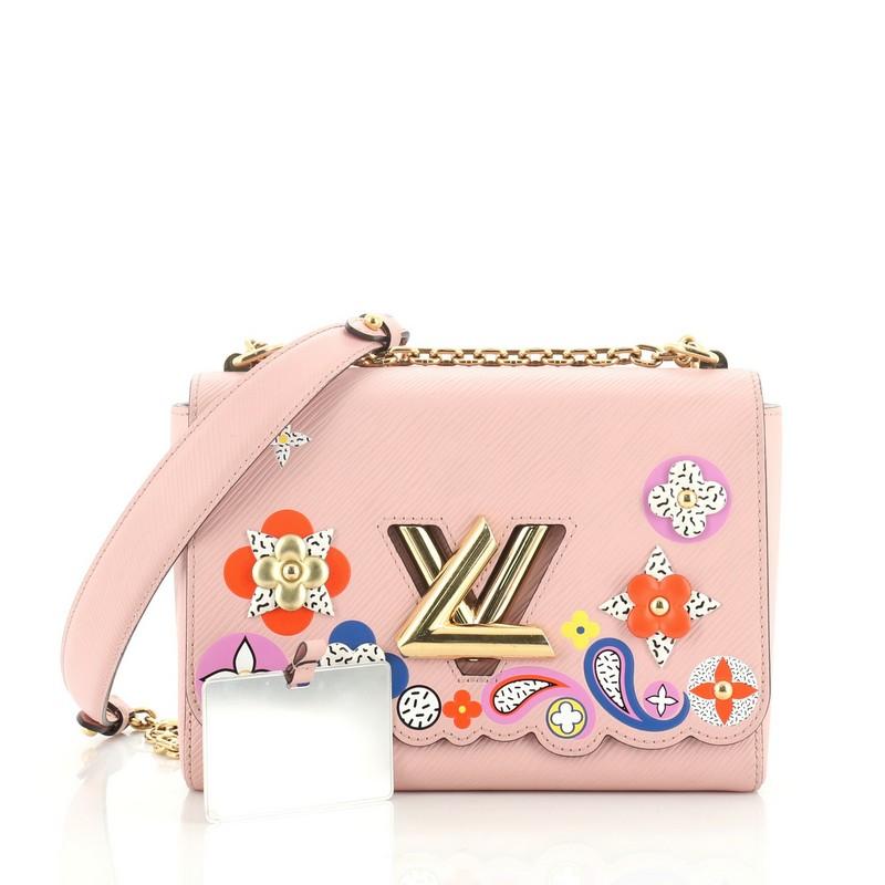 This Louis Vuitton Twist Handbag Limited Edition Bloom Flower Epi Leather MM, crafted from pink epi leather, features chain link strap with leather pad, multicolor bloom flowers, and gold-tone hardware. Its LV twist-lock closure opens to a pink