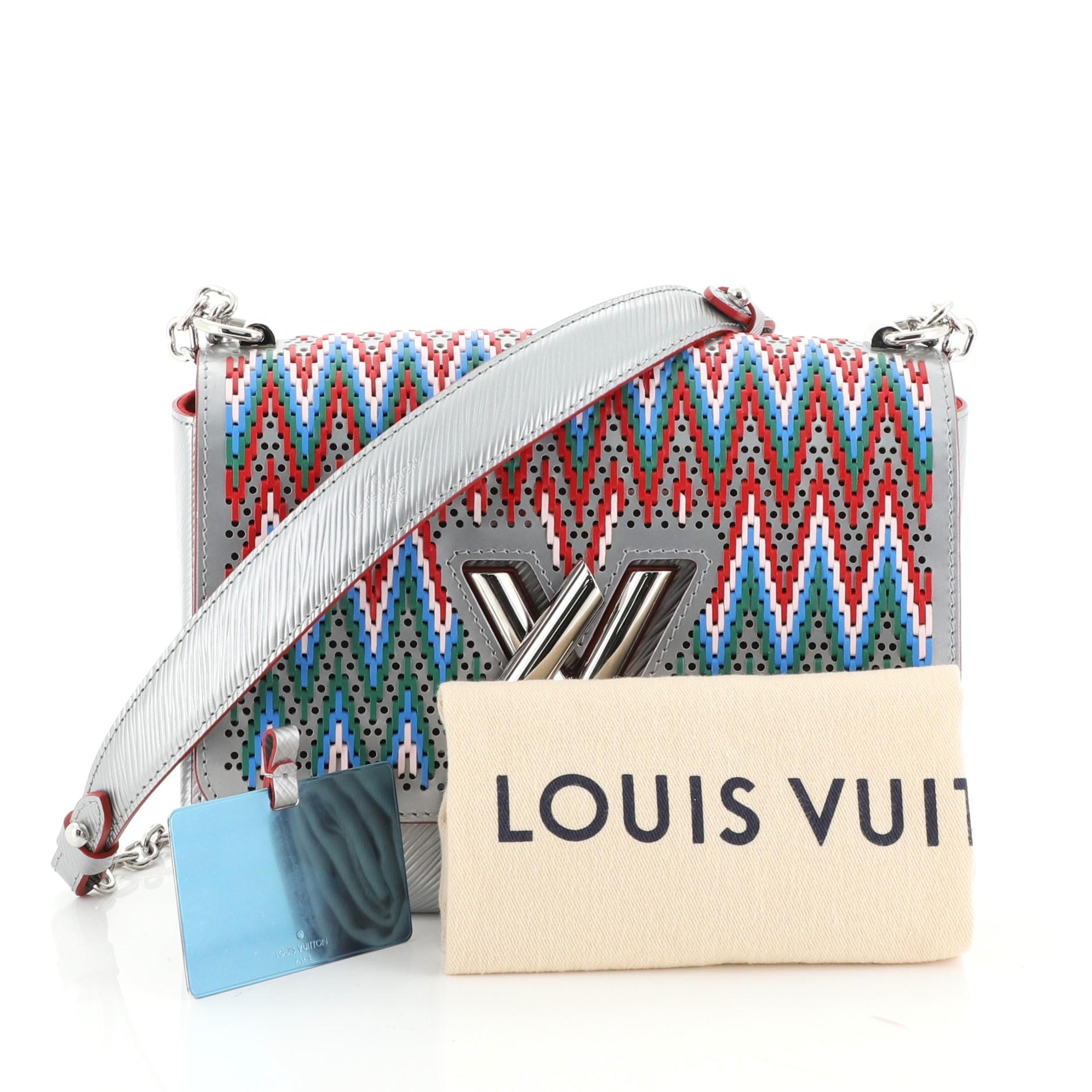 This Louis Vuitton Twist Handbag Limited Edition Stitched Epi Leather MM, crafted from silver stitched epi leather, features chain link strap with leather pad, frontal flap and silver-tone hardware. Its LV twist lock closure opens to a red