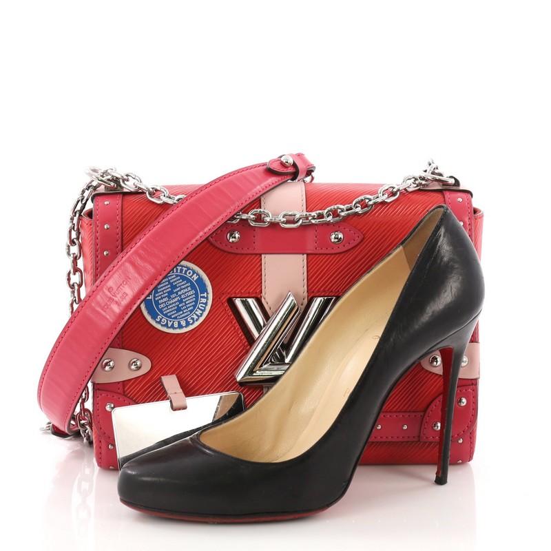 This Louis Vuitton Twist Handbag Limited Edition Trunks Epi Leather MM, crafted from red and pink epi leather, features a chain link strap with leather pad, frontal flap with unique LV twist lock closure, and silver-tone hardware. It opens to a red