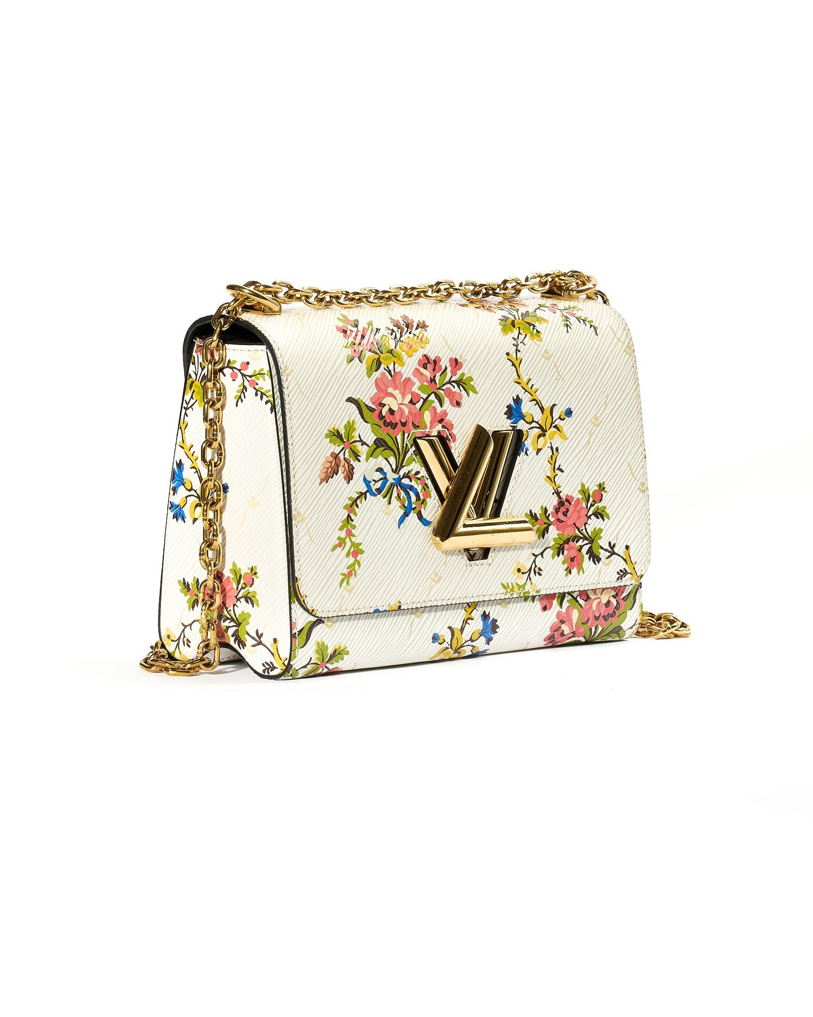 Louis Vuitton signature bag, size MM,  made of Epi leather with embossed floral print and gold hardware details. Features a front flap with the classic Twist logo and a swivel closure. The interior is lined with black suede fabric and includes a