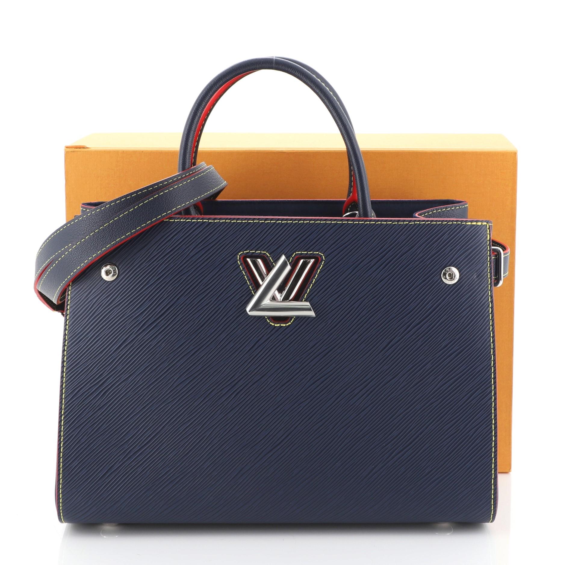 This Louis Vuitton Twist Tote Epi Leather, crafted in blue epi leather, features two toron handles, side body straps, and silver-tone hardware. Its iconic twist-lock closure opens to a blue microfiber interior with two open compartments with slip