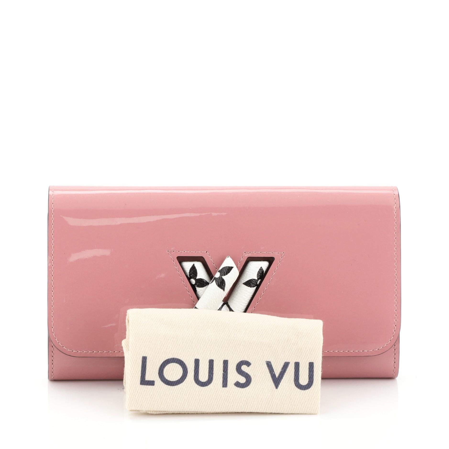 This Louis Vuitton Twist Wallet Vernis with Monogram Canvas, crafted from pink vernis with monogram canvas, features silver-tone hardware. Its LV twist lock closure opens to a pink leather interior with multiple card slots, middle zip coin pocket,