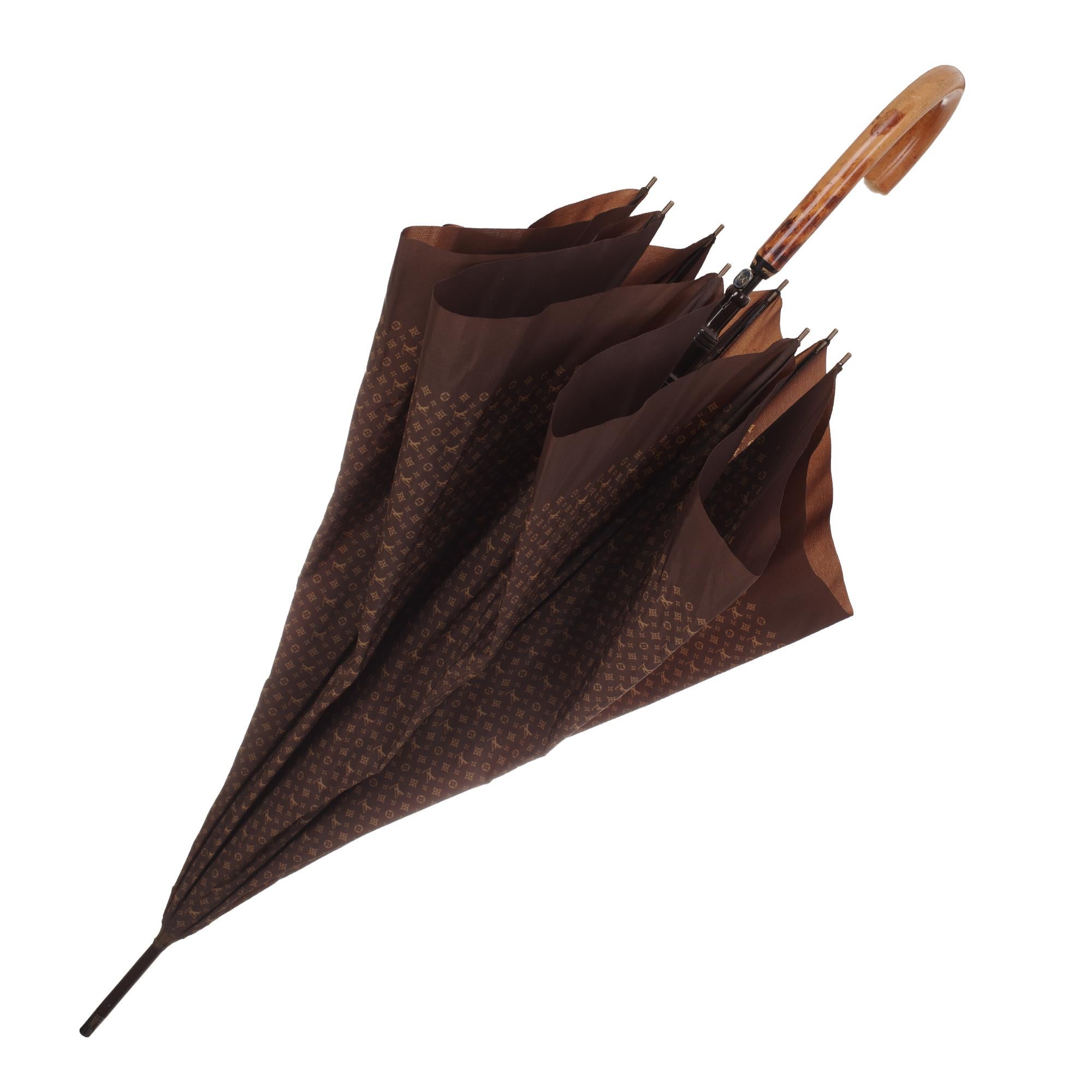 Louis Vuitton Stockschirm aus braunem Segeltuch:: bedruckt mit beigefarbenem Mini-Monogramm:: Schließe mit Knopf. 
Griff aus Holz. 
Höhe: 89 cm. 
Durchmesser: 105 cm. 
Unterschrift: 
