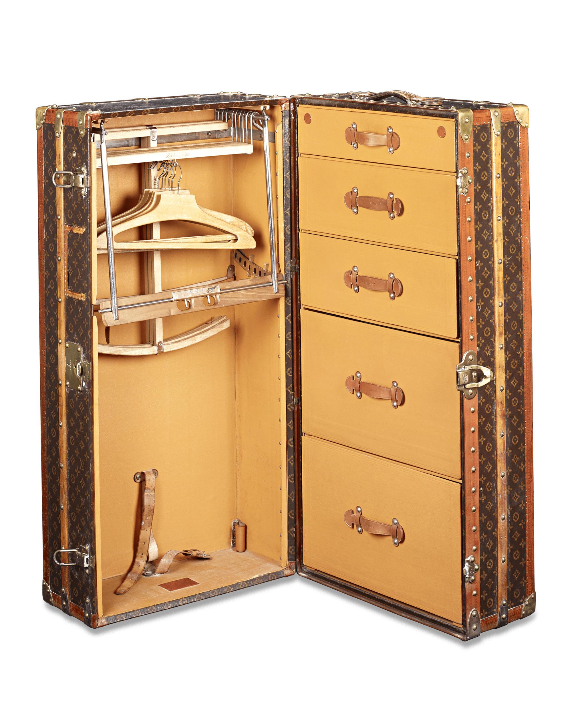 This rare and captivating antique Louis Vuitton upright wardrobe trunk embodies the elegance and sophistication of a bygone era. Boasting the iconic “LV” monogram on its canvas-upholstered frame, this trunk is fully outfitted to facilitate the most