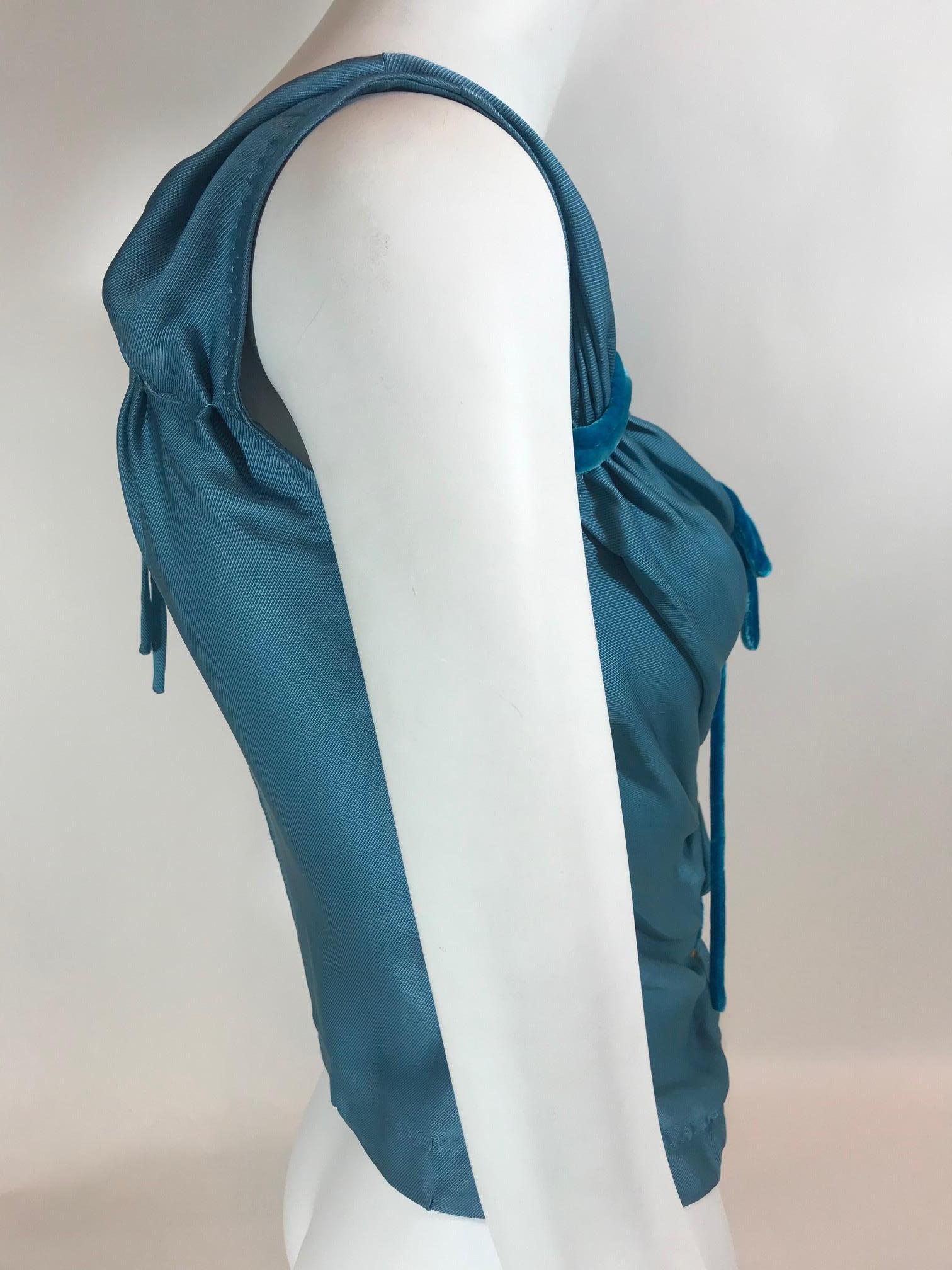 Medium teal blue sleeveless top with V-neck featuring velvet tie accents at front, and zip closure at back.