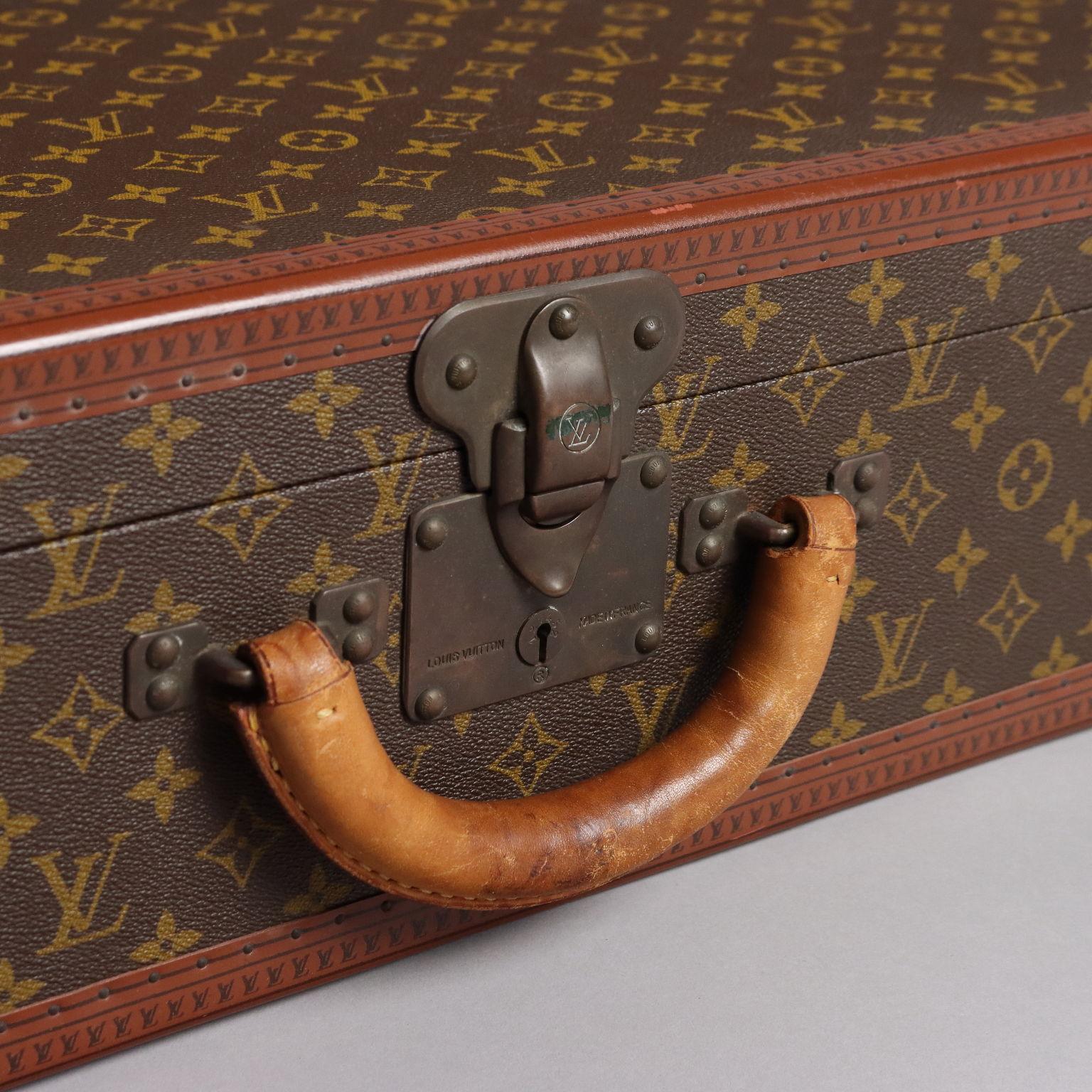 Louis Vuitton model Bisten 80 hard suitcase in the iconic monogram canvas, dating from the 1970s. The interior is lined and the handles rounded with leather; the corners are brass and the edges are lozine, a very durable volcanic fiber. Serratura a