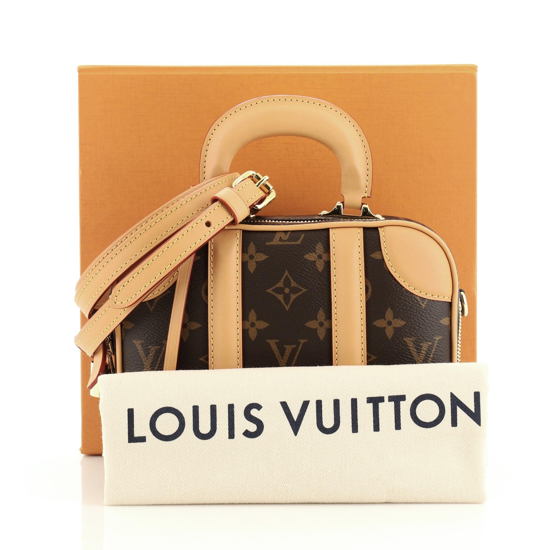 This Louis Vuitton Valisette Handbag Monogram Canvas BB, crafted from brown monogram coated canvas, features single top handle, cowhide leather trim and gold-tone hardware. Its zip closure opens to a neutral microfiber interior. Authenticity code