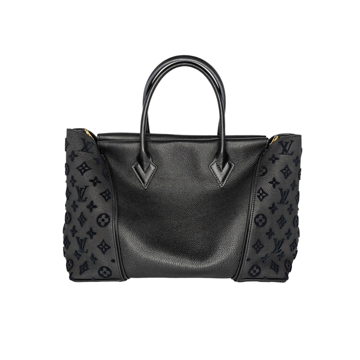 This luxurious and elegant handbag is finely crafted in black hue and features the monogram pattern in velvet on the sides. The top is secured with hidden magnetic closures, and opens to a roomy suede interior with two hanging zippered