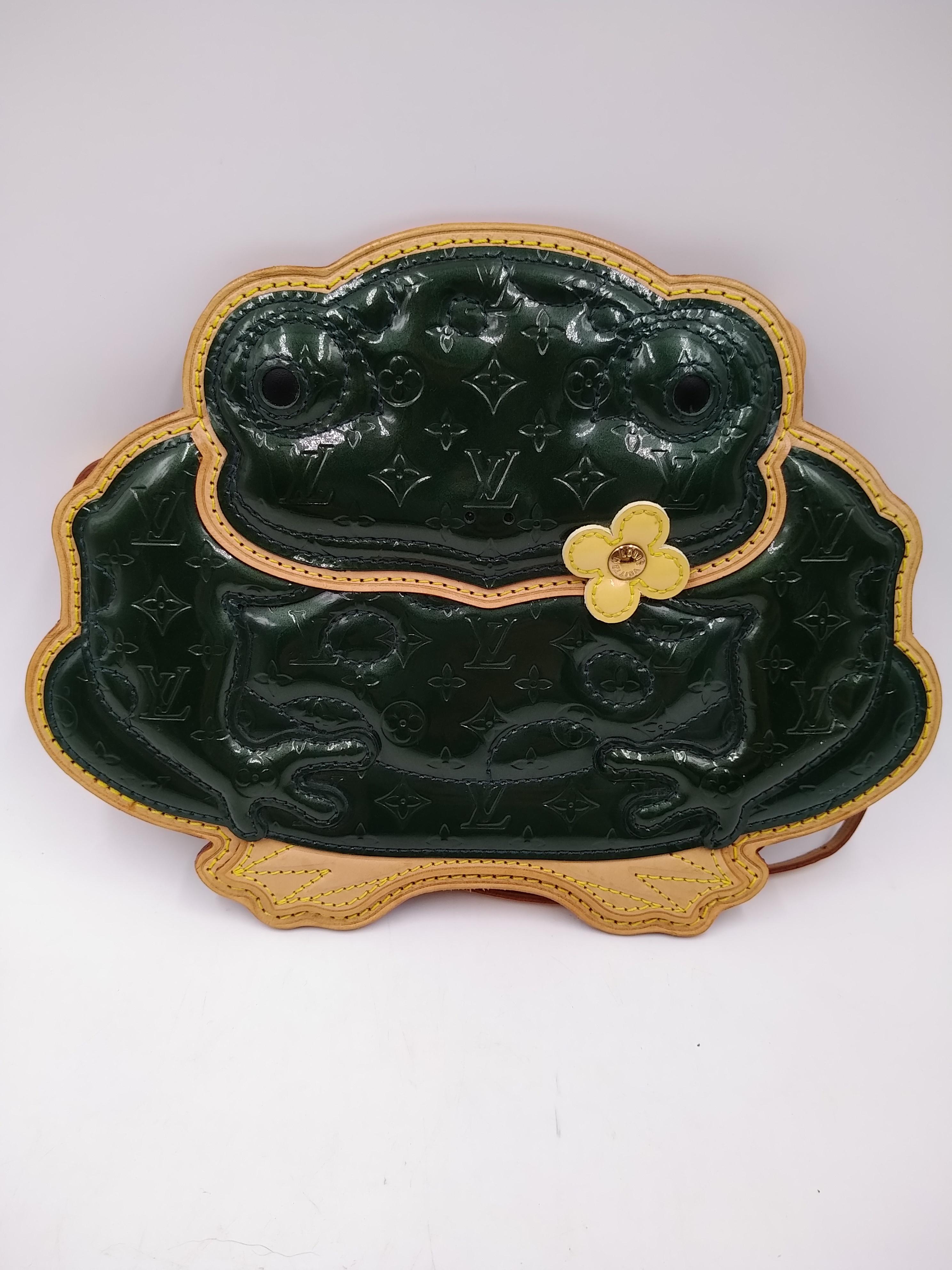 Louis Vuitton Vernis Conte de Fees Borsa a tracolla con rana Edizione Limitata 2002
- 100% autentico Louis Vuitton
- Pelle verniciata verde con finiture in pelle di vacchetta
- Motivo del Monogram in rilievo
- Chiusura con zip sul retro
- Tracolla