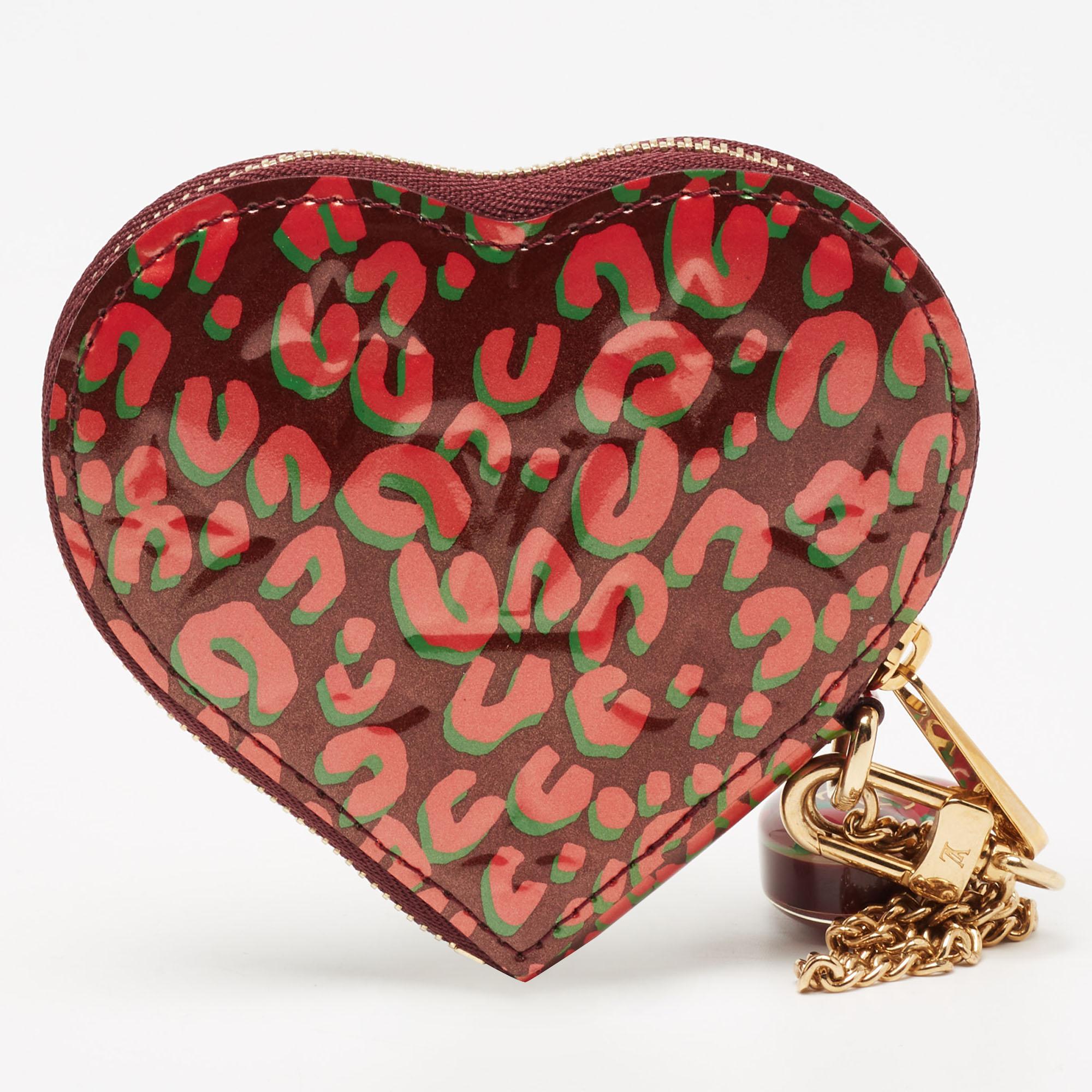 This coin case from Louis Vuitton is a delightful creation. The heart-shaped purse has been wonderfully crafted from the signature Vernis leather and flaunts an LV padlock charm. The top zipper closure of the purse opens to reveal a leather-lined