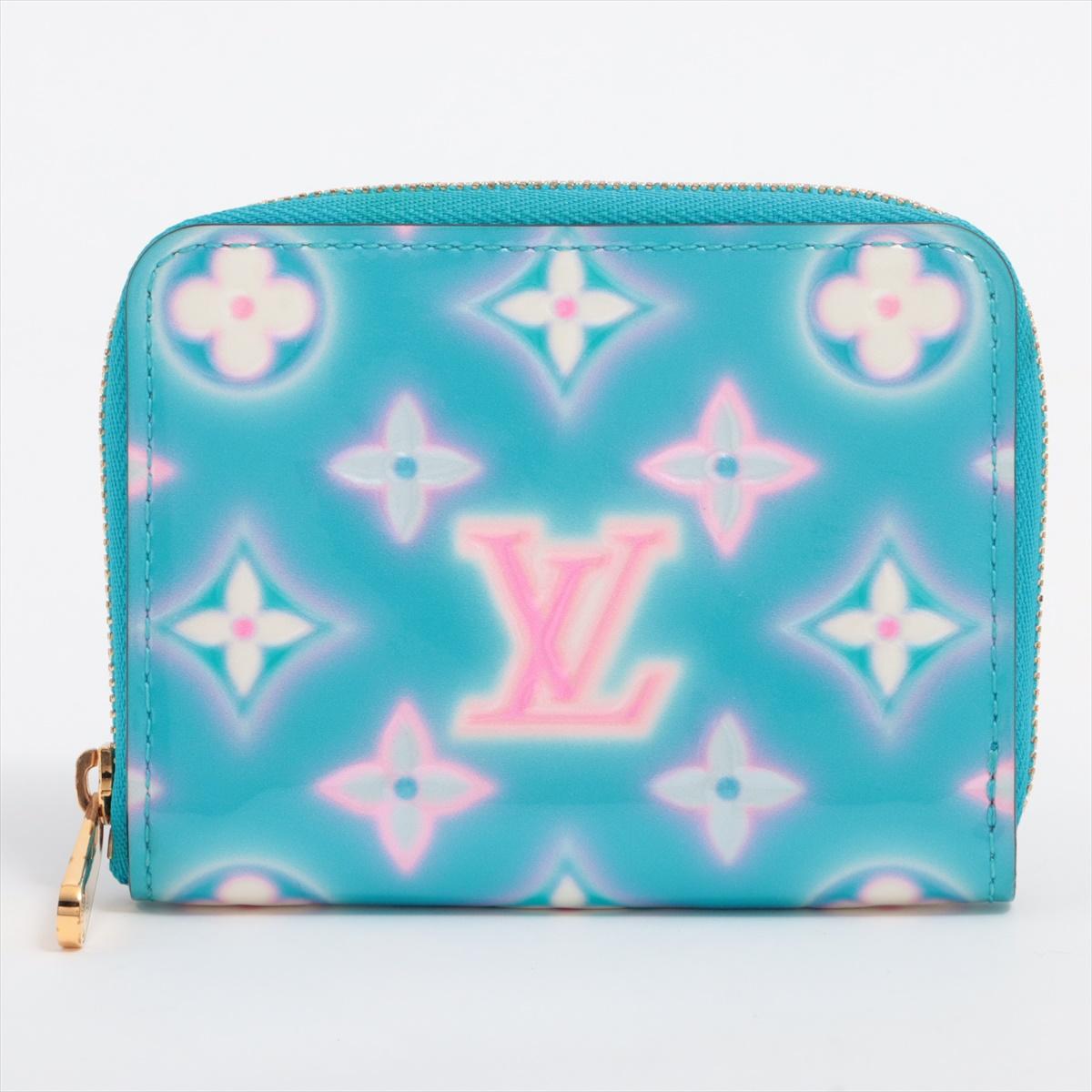 The Louis Vuitton Vernis Zippy Coin Purse in Baby Blue Neon x Pink is a vibrant and playful accessory that adds a pop of color to any ensemble. Crafted from Vernis patent leather, the coin purse boasts a glossy finish that catches the eye. The