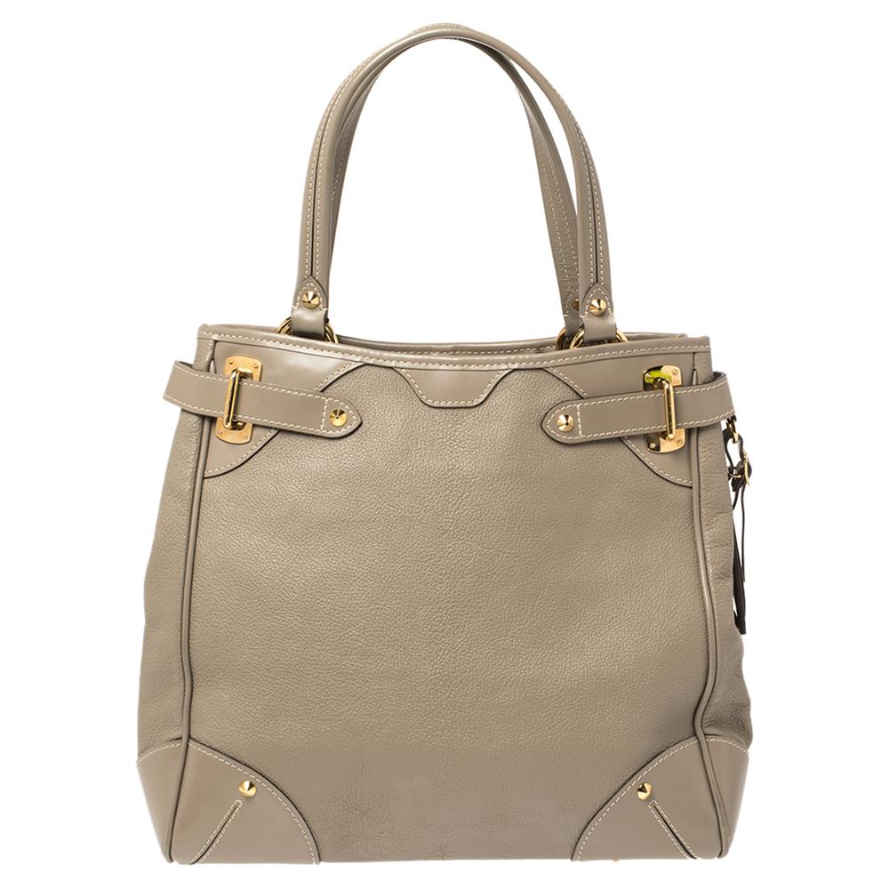 Diese elegante LV-Tasche ist Teil der Suhali-Kollektion. Die aus Suhali-Leder gefertigte Tasche ist mit Schnallendetails und goldfarbenen Metallnieten an den Rändern und am Boden akzentuiert. Die Kreation wird von zwei Griffen an der Oberseite