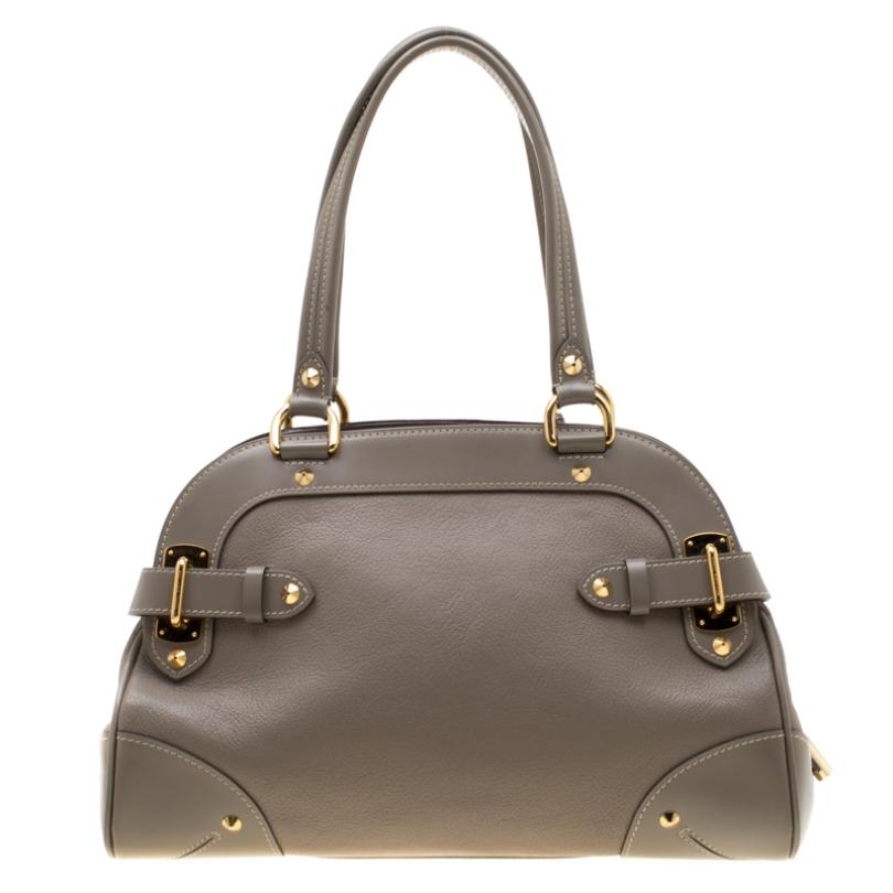 This Le Radieux bag from Louis Vuitton is gorgeous. The grey beauty is crafted from leather and flaunts a unique and distinctive style. It features beautiful gold-tone studs, buckles, and the lock accent all of which shine to make it an enchanting
