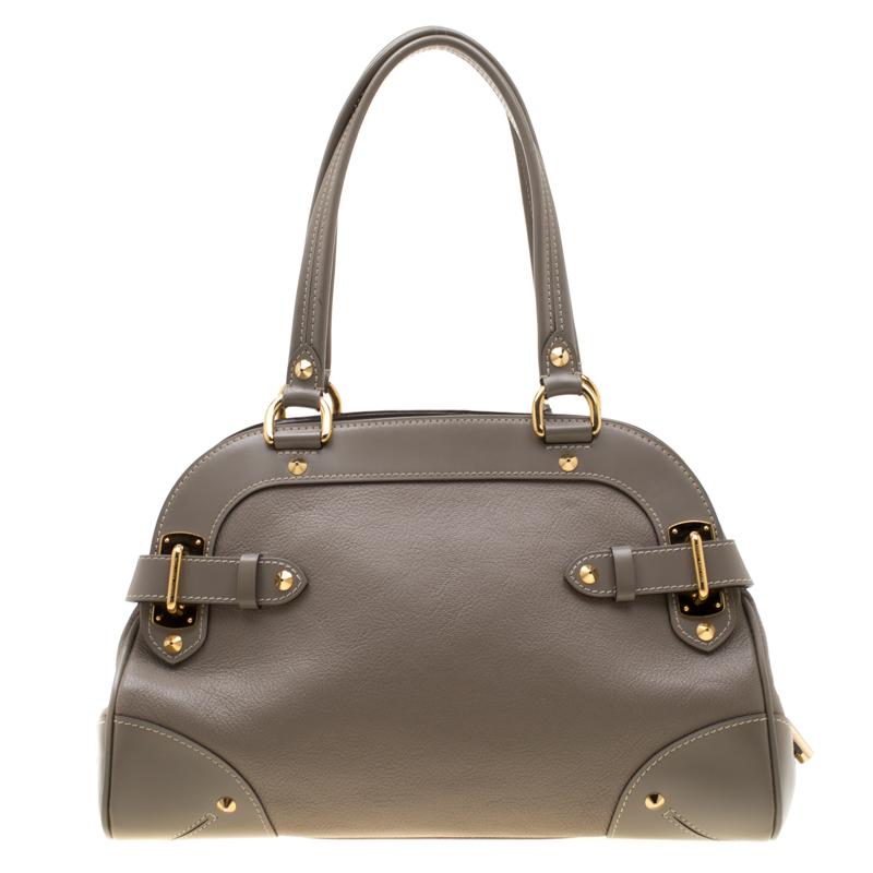Diese Le Radieux Tasche von Louis Vuitton ist wunderschön. Die graue Schönheit ist aus Leder gefertigt und zeichnet sich durch einen einzigartigen und unverwechselbaren Stil aus. Die schönen goldfarbenen Nieten, Schnallen und der Schlossakzent