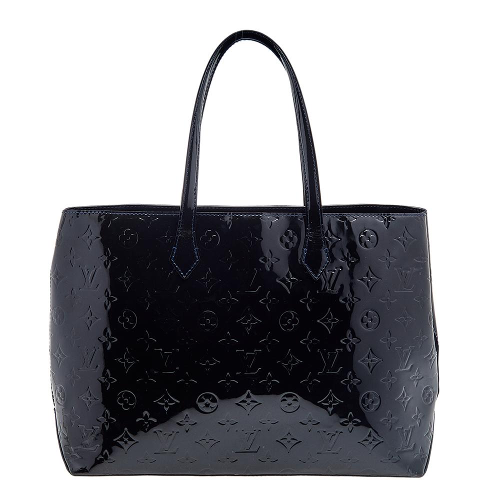 Louis Vuitton's handbags are popular owing to their high style and functionality. This Wilshire bag, like all the other handbags, is durable and stylish. Crafted from Monogram Vernis, the bag comes with dual handles and a hook that opens to reveal a