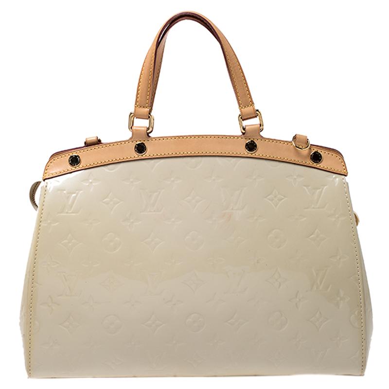 The feminine shape of Louis Vuitton's Brea is inspired by the doctor's bag. Crafted from Monogram Vernis in beige, the bag has a perfect finish. The fabric interior is spacious and it is secured by a zipper. The bag features double handles,