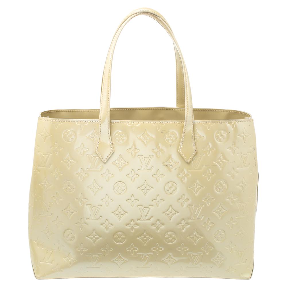 Louis Vuitton's handbags are popular owing to their high style and functionality. This Wilshire bag, like all the other handbags, is durable and stylish. Crafted from patent leather, the bag comes with dual handles and opens to reveal a fabric-lined