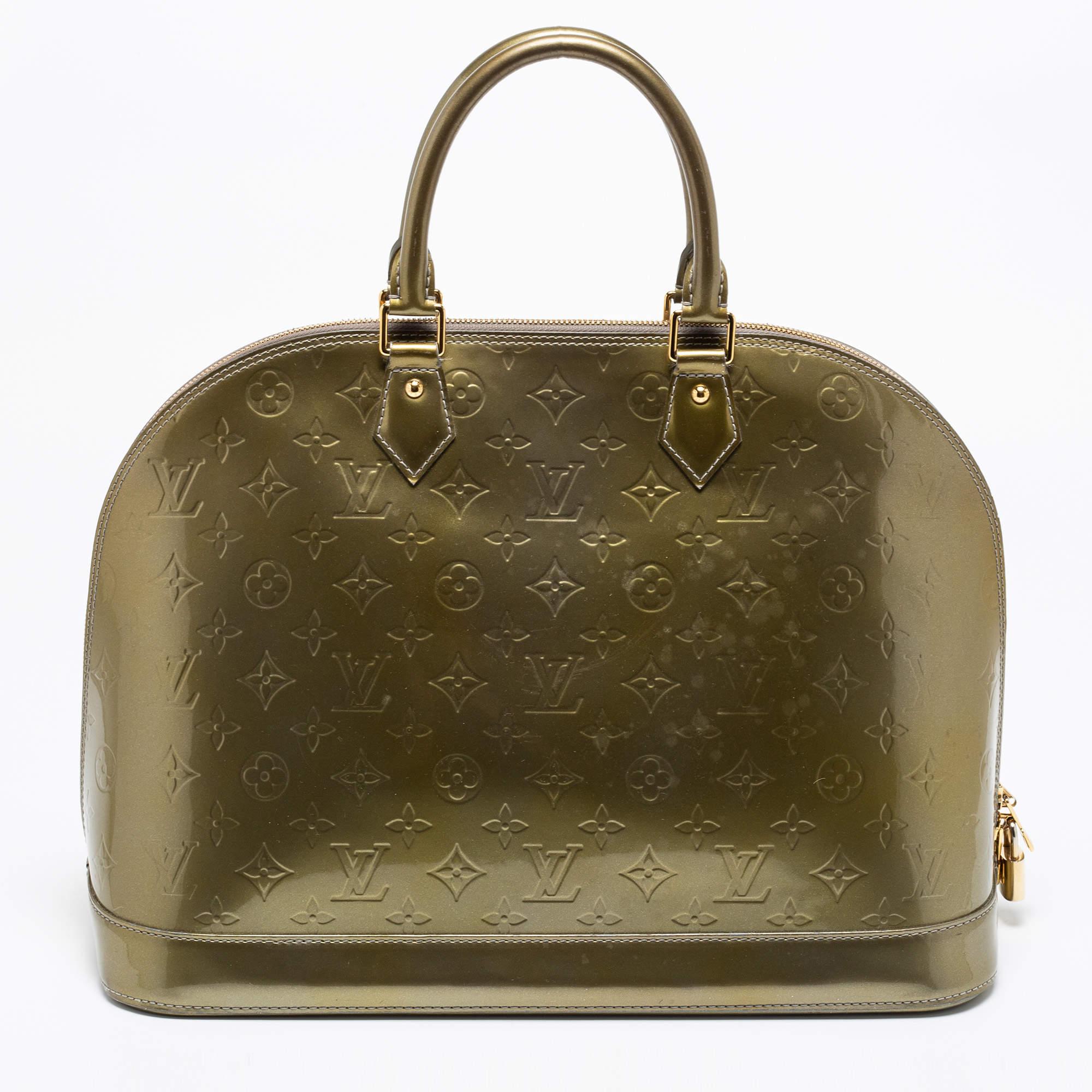 From one of the most iconic collections of Louis Vuitton, this Alma bag is imbued with exquisite craftsmanship and historic details. Constructed from Vert Olive Monogram Vernis leather, it displays dual handles at the top, gold-tone hardware, and a