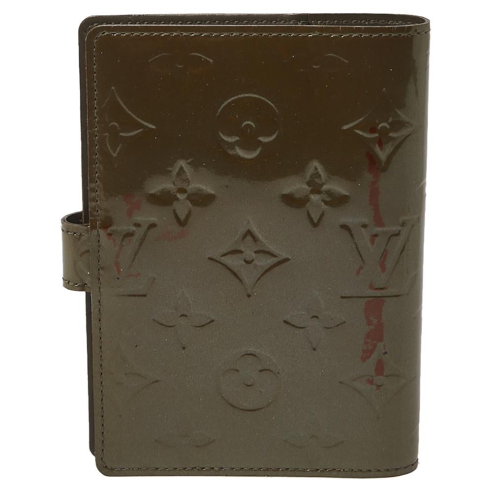 This compact and functional Louis Vuitton agenda cover in monogram Vernis can be used as an address book, calendar, or notepad. It features multiple credit card slots and a press stud closure.

