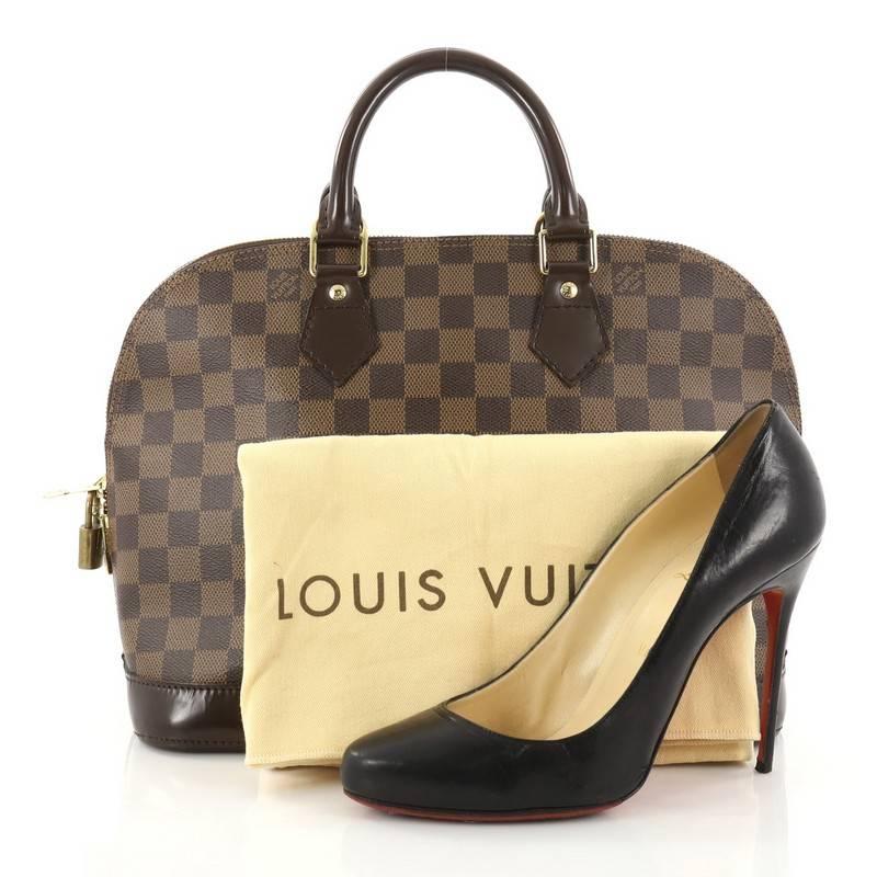 This authentic Louis Vuitton Vintage Alma Handbag Damier PM is an elegant spin on a classic style that is perfect for all seasons. Crafted from Louis Vuitton's damier ebene coated canvas, this dome-shaped satchel features dual-rolled handles, dark