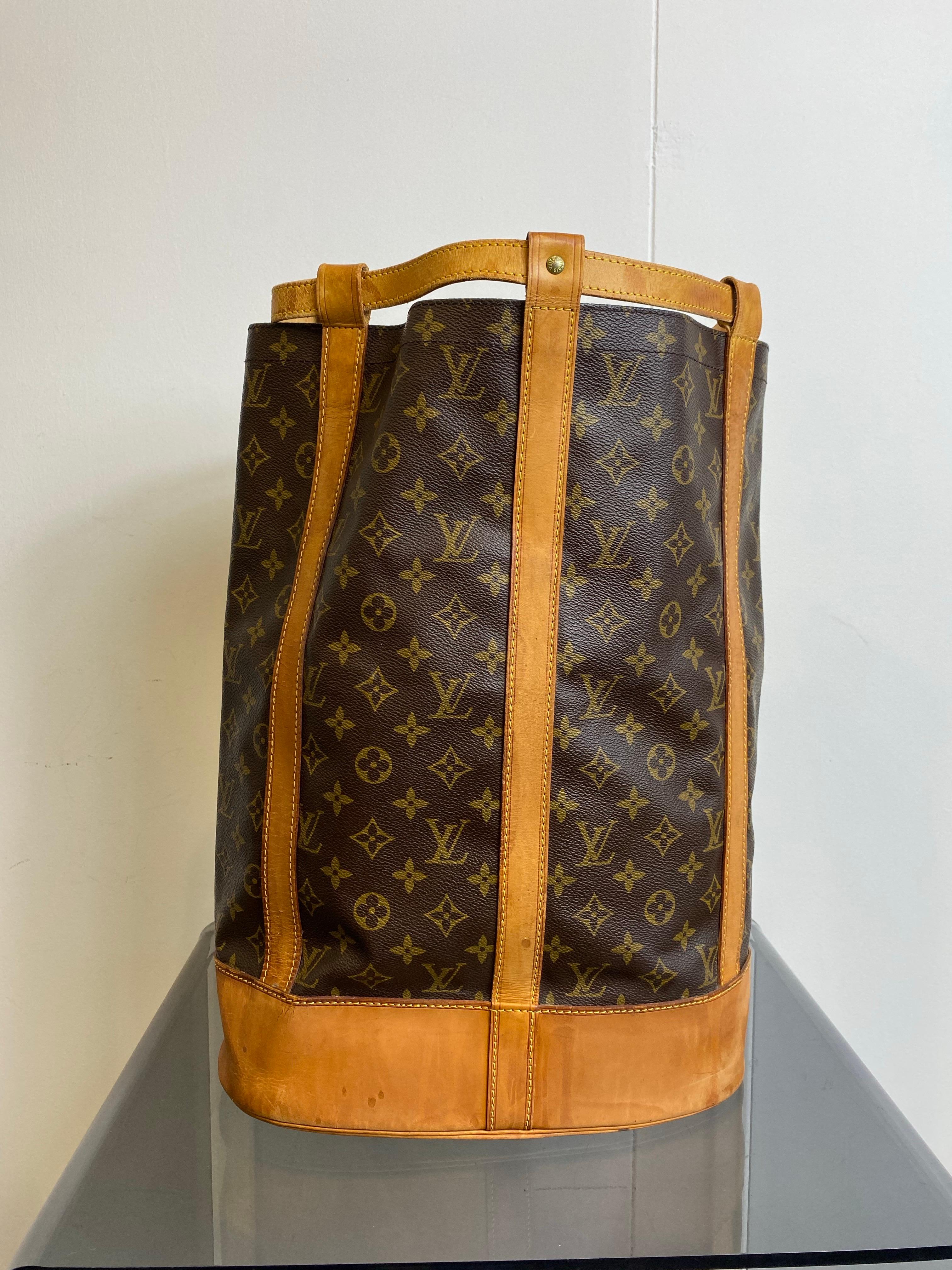 Sac vintage Louis Vuitton mod�èle Randonnee GM. 
Toile avec logo et détails en cuir. Modèle de type sac à dos avec bandoulière réglable. Vintage et donc montre des signes typiques d'utilisation comme vu dans les photos mais rien n'est cassé.