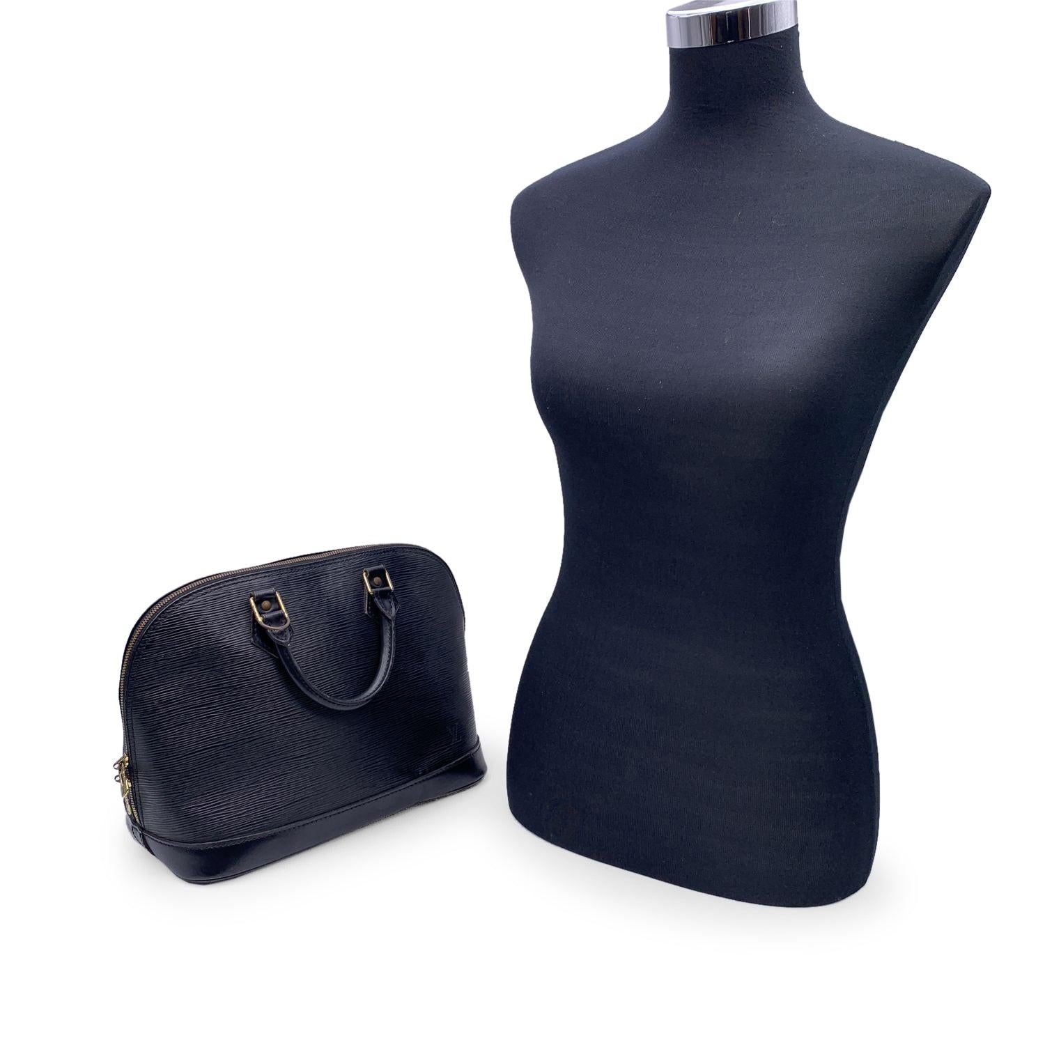 Indulge in the timeless sophistication of the Louis Vuitton Vintage Black Epi Leather Alma Satchel Top Handle Bag, a true icon of luxury and craftsmanship. Produced in France between 1990 and 1999, this Alma model remains a classic favorite for