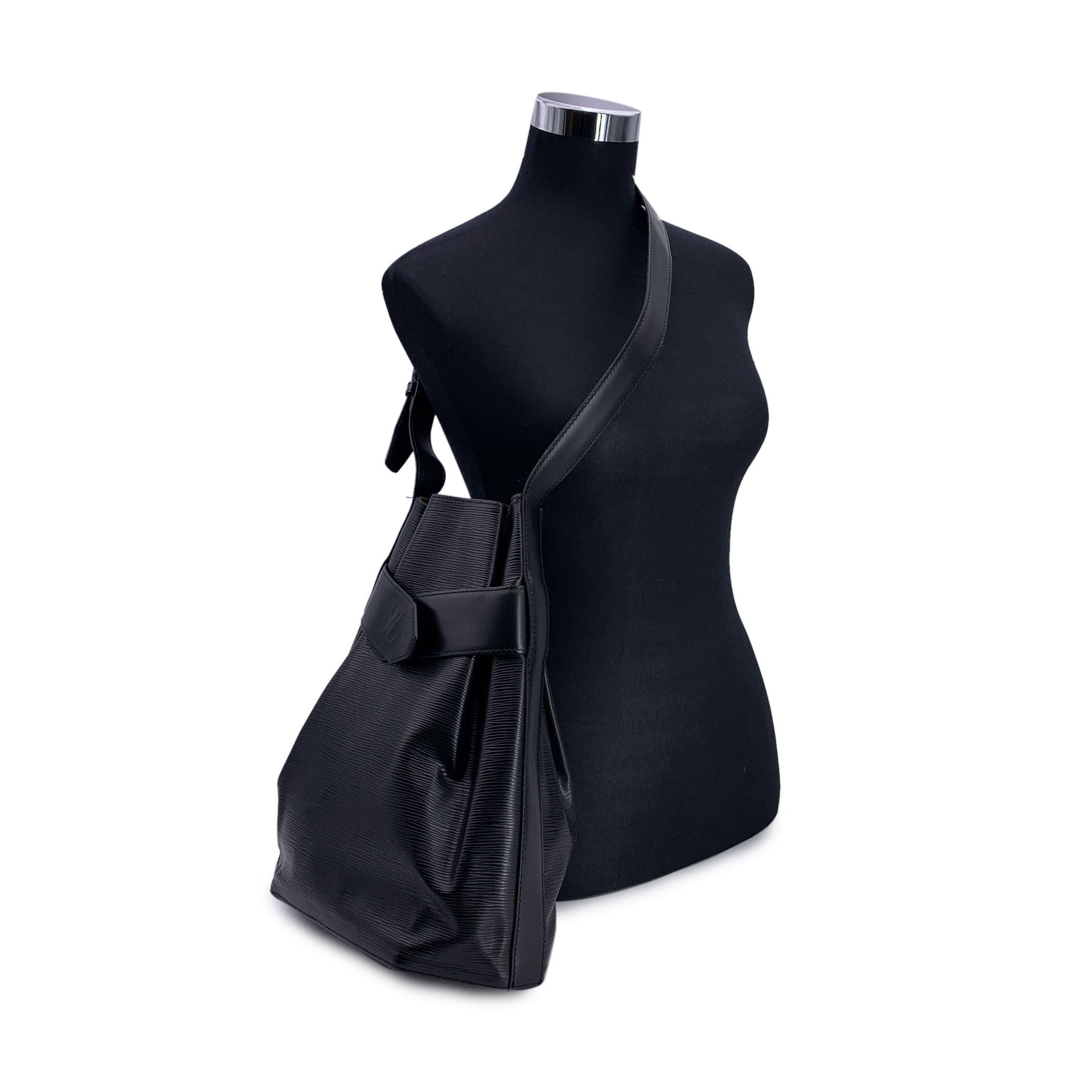 A refined classic from the Louis Vuitton archives, this 'Sac d'Épaule' Shoulder Bag is a striking example of minimalist sophistication. Crafted in black Epi leather - known for its textured elegance and durability - this now discontinued model is a