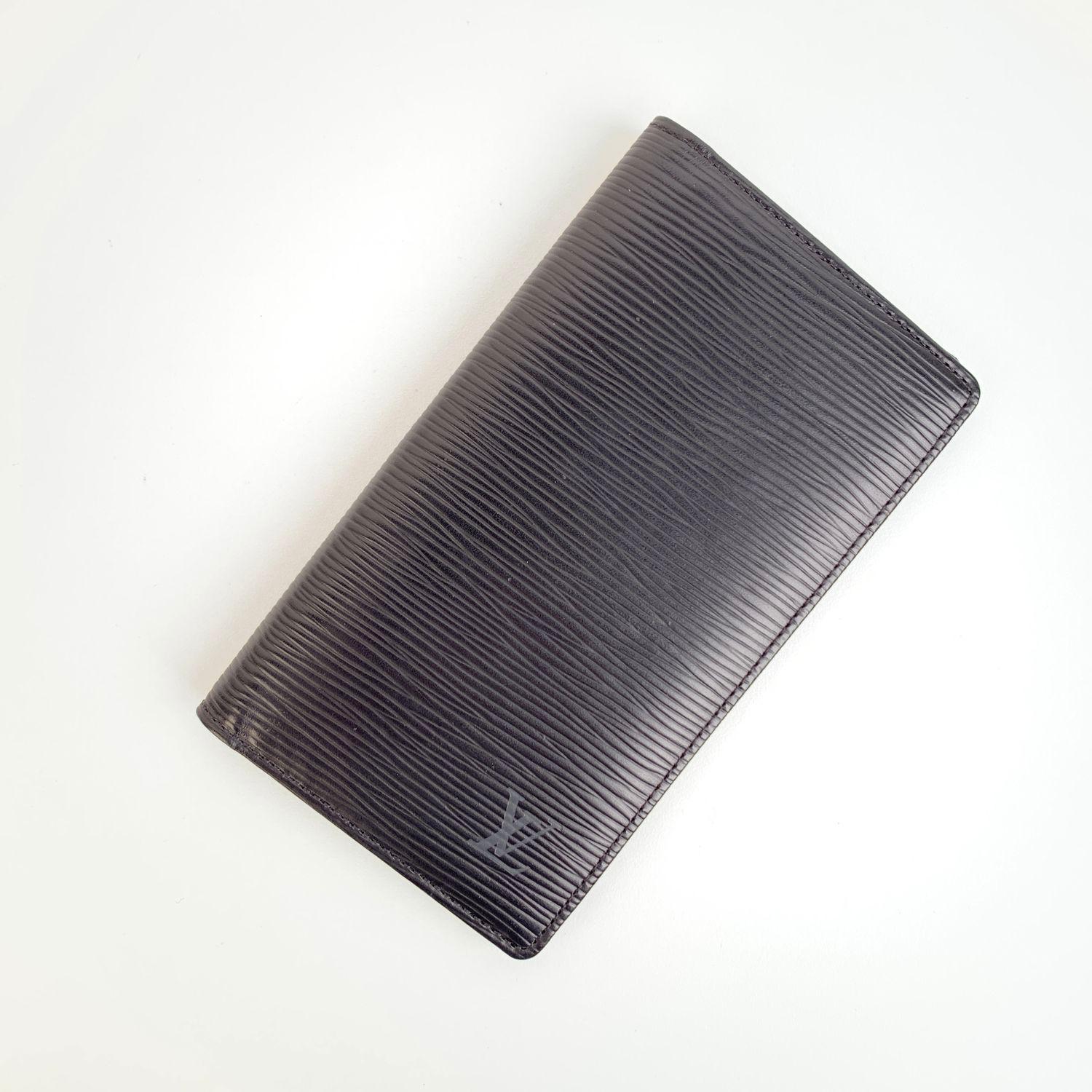 Vintage Louis Vuitton Black Epi Leather Vertical Wallet with checkbook holder. . LV - LOUIS VUITTON logo embossed on the front. 2 side pockets, 3 credit card slots. Date code / Authenticity Serial Number CA1916 (January 1996) inside one of the