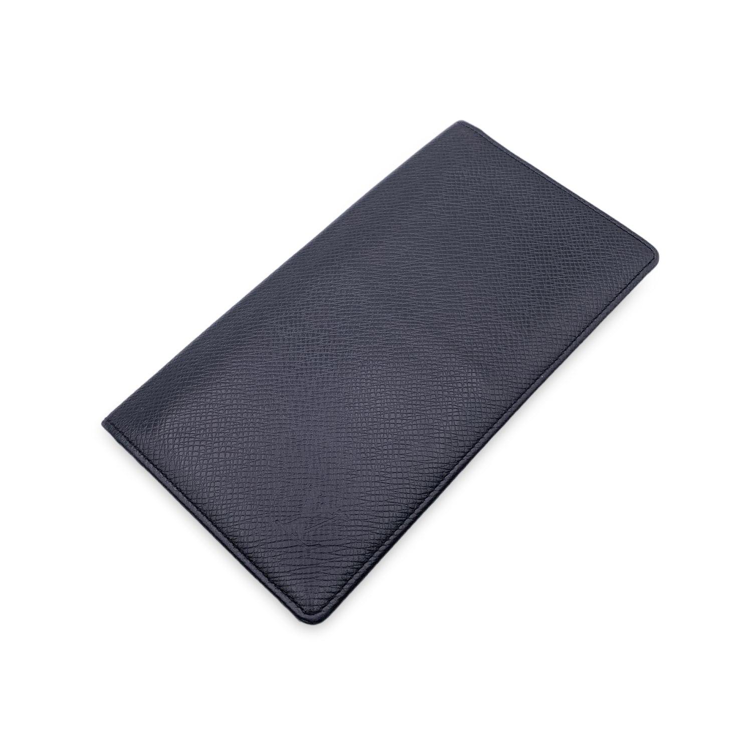 Elevate your everyday essentials with this Louis Vuitton Black Taiga Leather Porte Chequier Checkbook and Credit Card holder. A perfect blend of functionality and luxury, this piece is crafted from Louis Vuitton's signature Taiga leather, known for