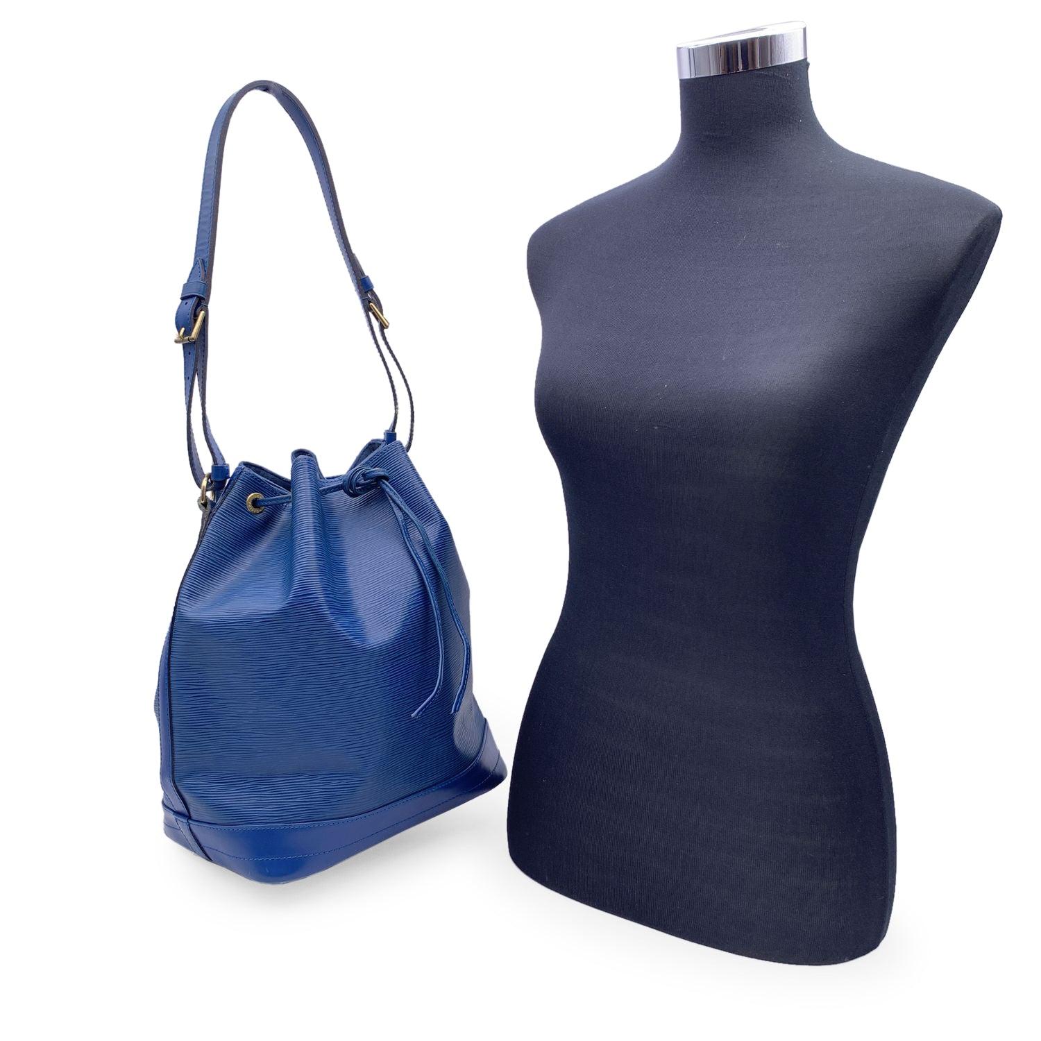 Iconic 'Noé' bucket bag by LOUIS VUITTON was first created in 1932 to carry champagne bottles. Blue Epi leather with smooth leather trim at the bottom, with drawstring closure and microfiber lining. 1 D-Ring inside, Adjustable shoulder strap. LV -