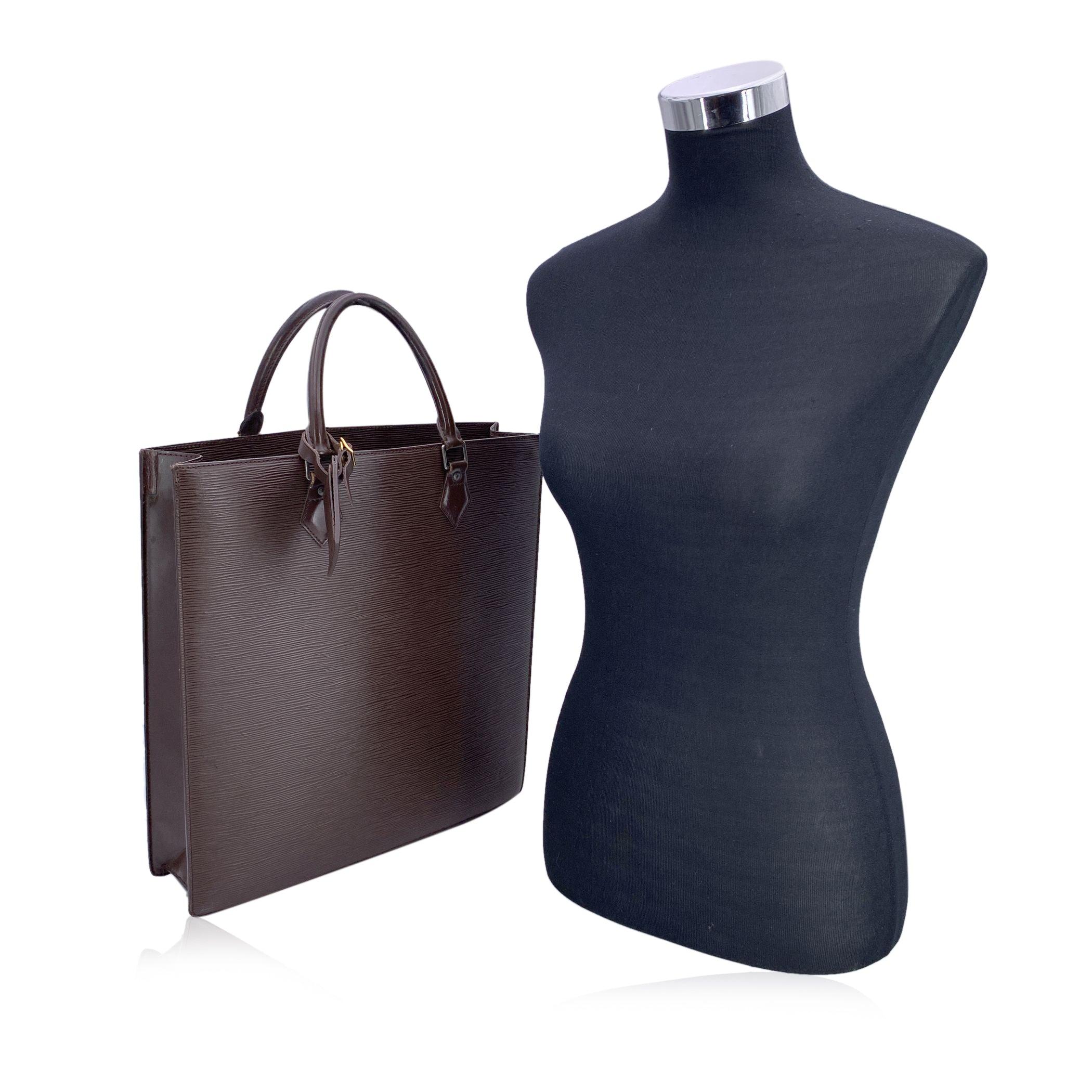 Step into the world of timeless luxury with this vintage Louis Vuitton 'Sac Plat' tote bag, an iconic piece that exudes sophistication and style. Crafted from the signature brown Epi leather, this tote showcases a beautiful textured finish that is