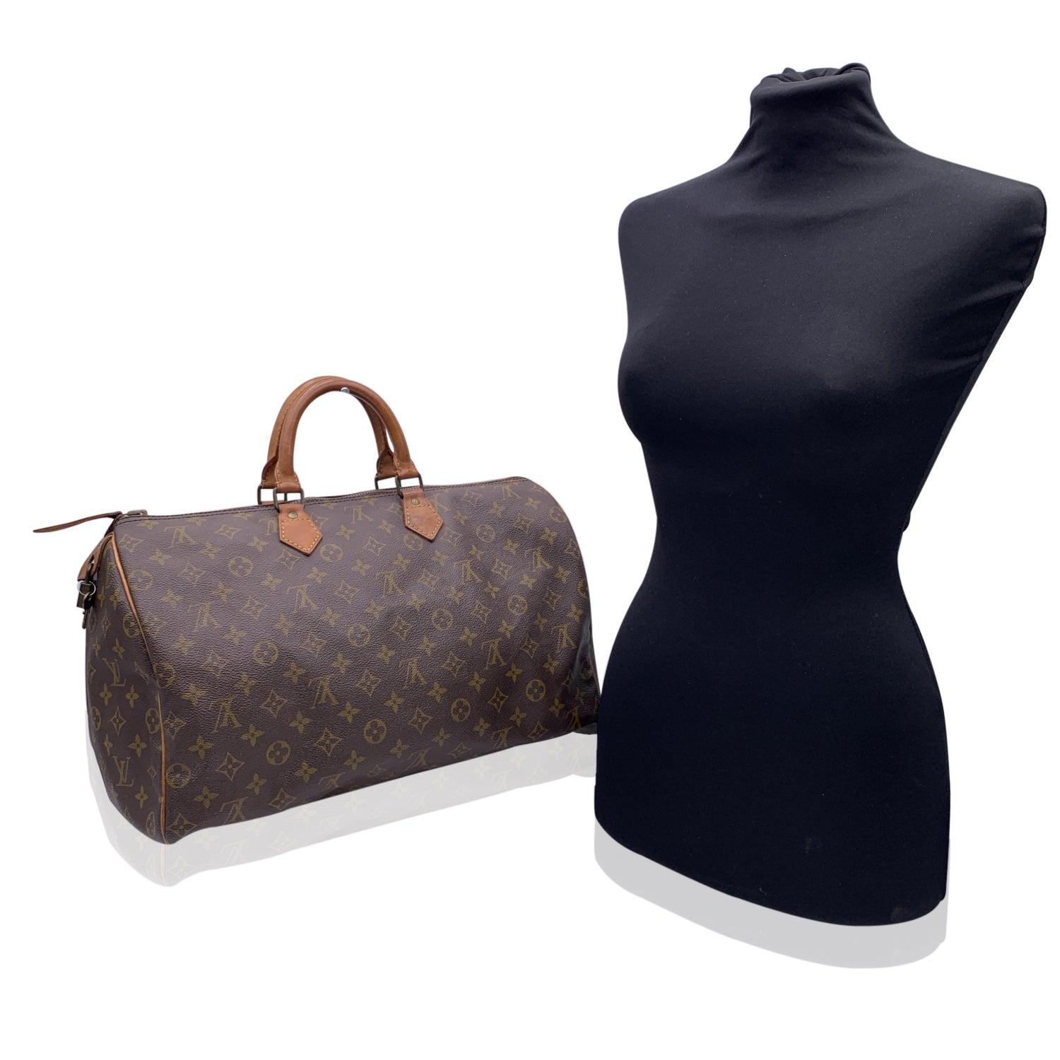 This classic Louis Vuitton SPEEDY 40, one of the most popular lines in the LV monogram. Upper zipper closure. Padlock and key included. Brown fabric lining. Natural leather handles and piping. LV - LOUIS VUITTON monograms on canvas ,'LOUIS VUITTON