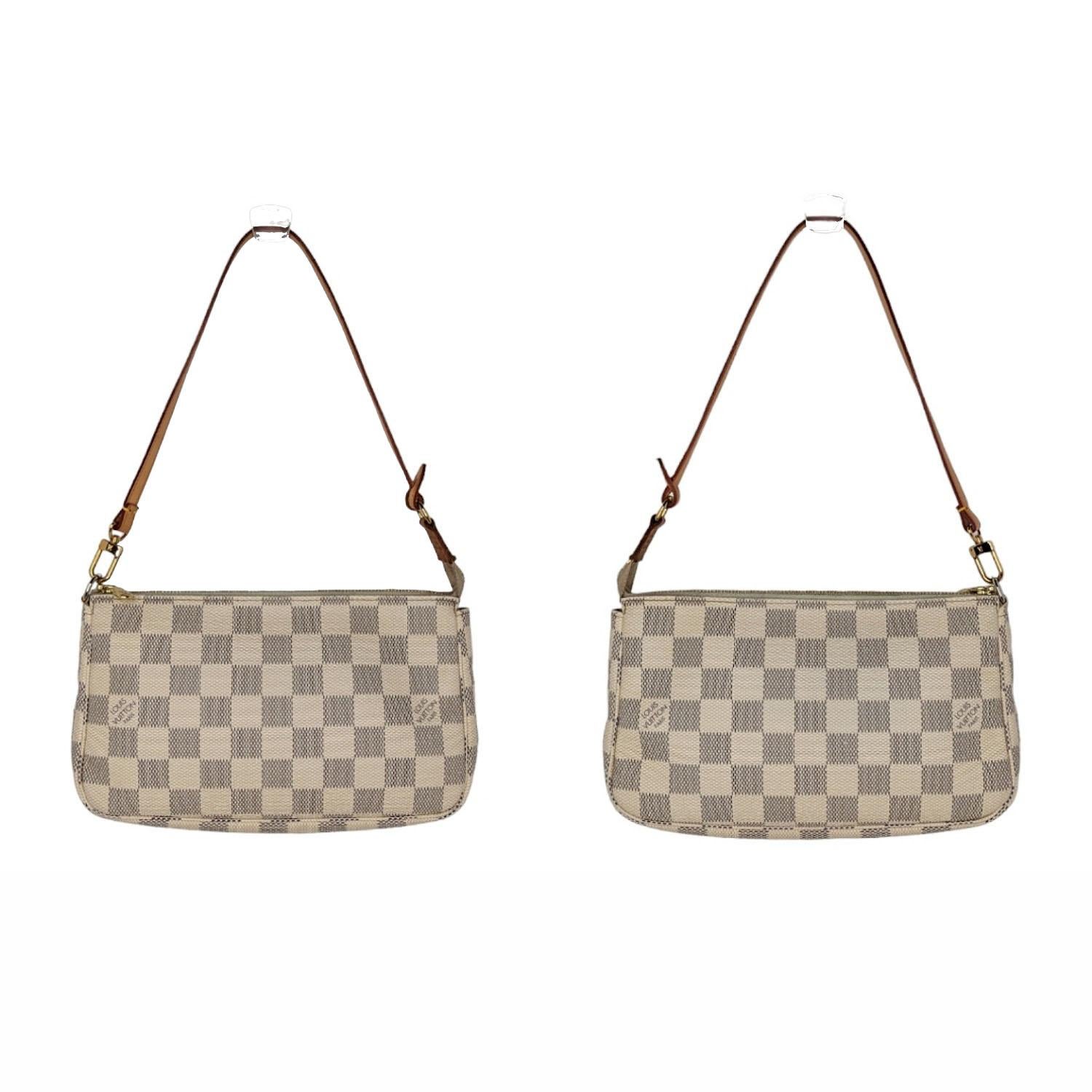 This pochette is crafted of Louis Vuitton's signature Damier canvas in blue and white. The bag features a vachetta leather strap and a brass top zipper that opens to a beige fabric interior. Retail $1,290.

Designer: Louis Vuitton
Material: Damier