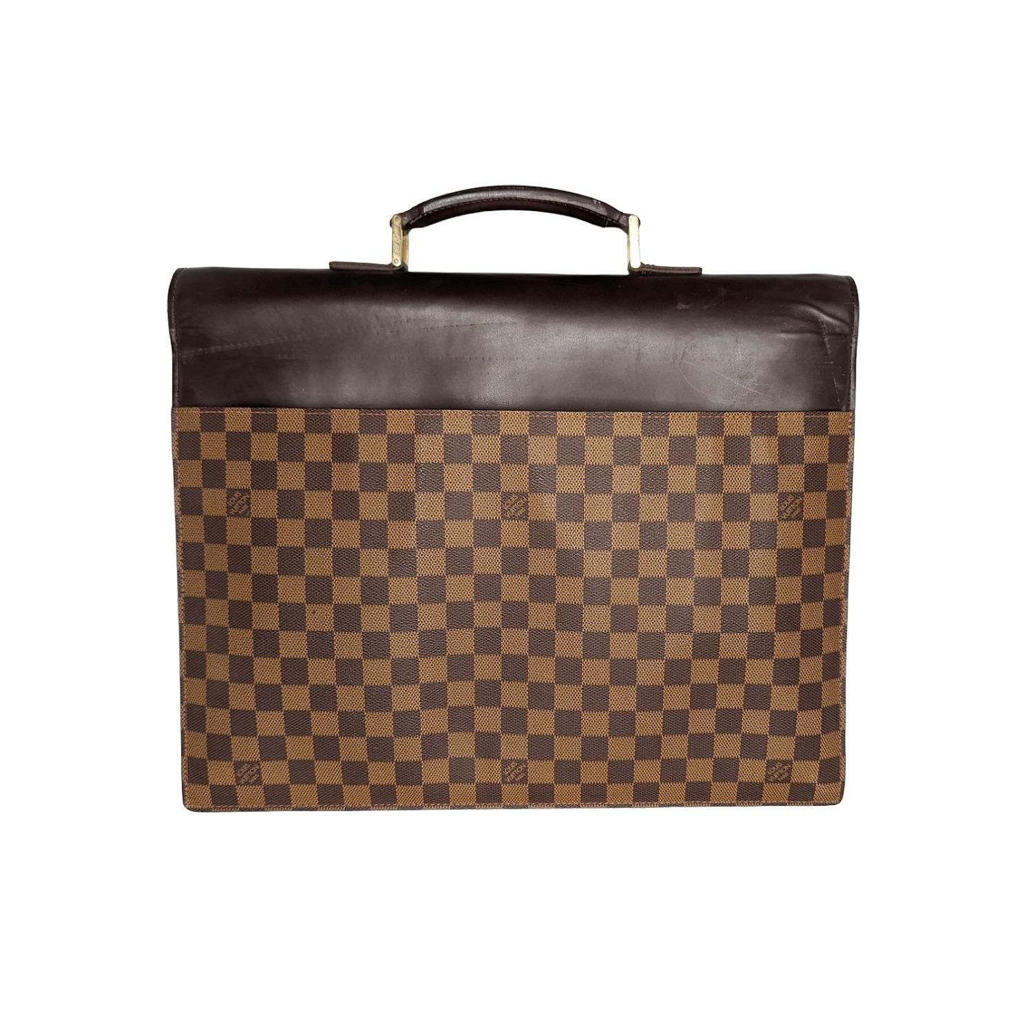 This handsome briefcase is crafted of Louis Vuitton signature damier canvas. There is a reinforced leather top handle with brass links and a smooth leather cross-over flap with a brass press lock. This opens to a spacious cocoa Alcantara interior