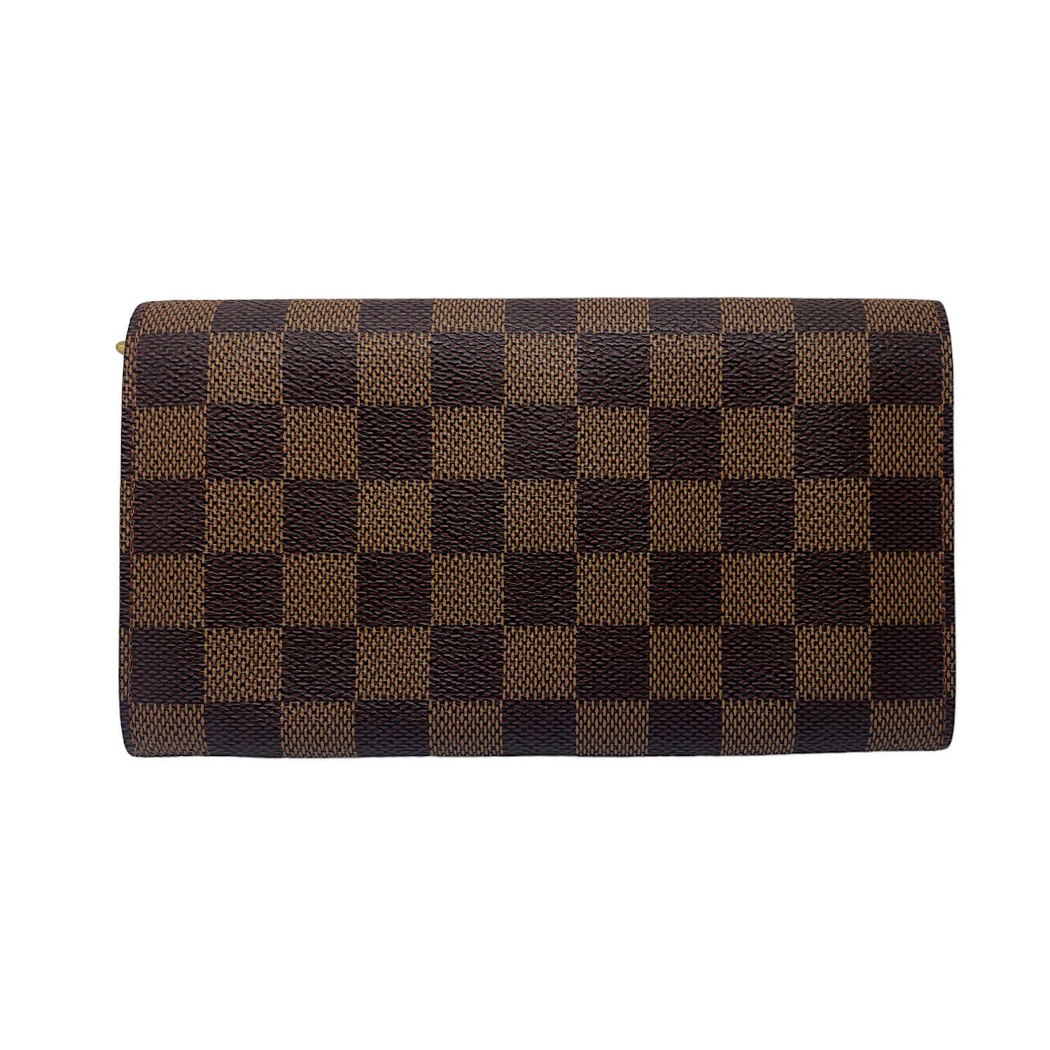Brown and tan damier ebene coated canvas Louis Vuitton Sarah Wallet with brass hardware, single slit pocket at back, three interior compartments; one with zip closure, leather lining, Dual slip pockets. slip pocket, single bill compartment, snap