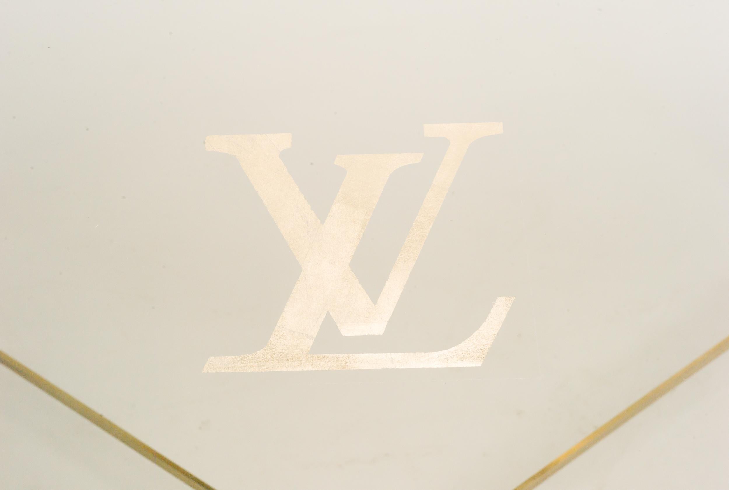 Display table with gold Louis Vuitton monogram. 
This was a display table for the Louis Vuitton presentation at Harrods in London many years ago. 
Brass frame, stained glass top with gold LV logo. 
Very distinctive piece.