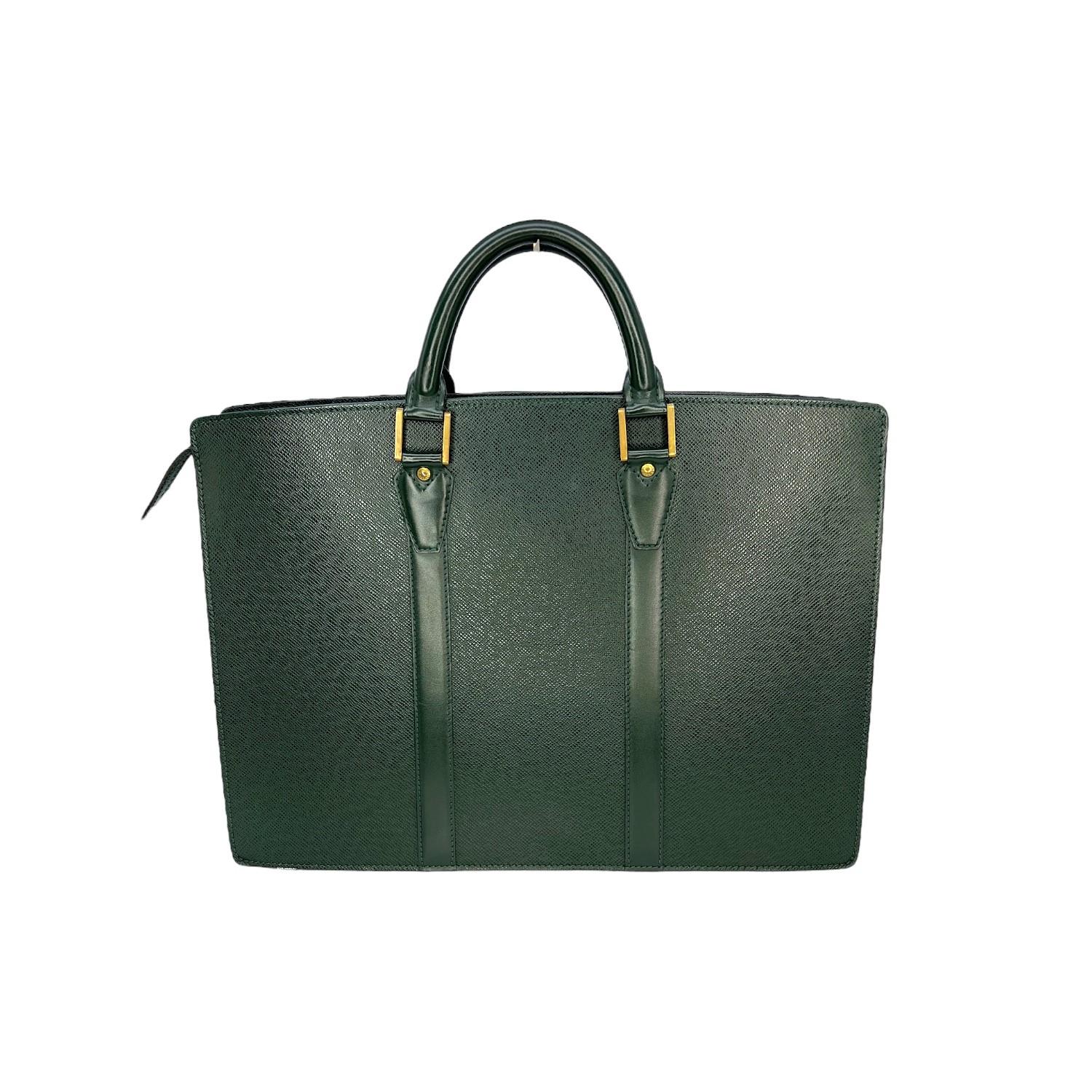 This Louis Vuitton Taiga Portfolio Briefcase is finely crafted of the green Louis Vuitton Taiga leather exterior with leather trimming and gold-tone hardware features. It has dual rolled leather top handles. It features twin slip pockets on the