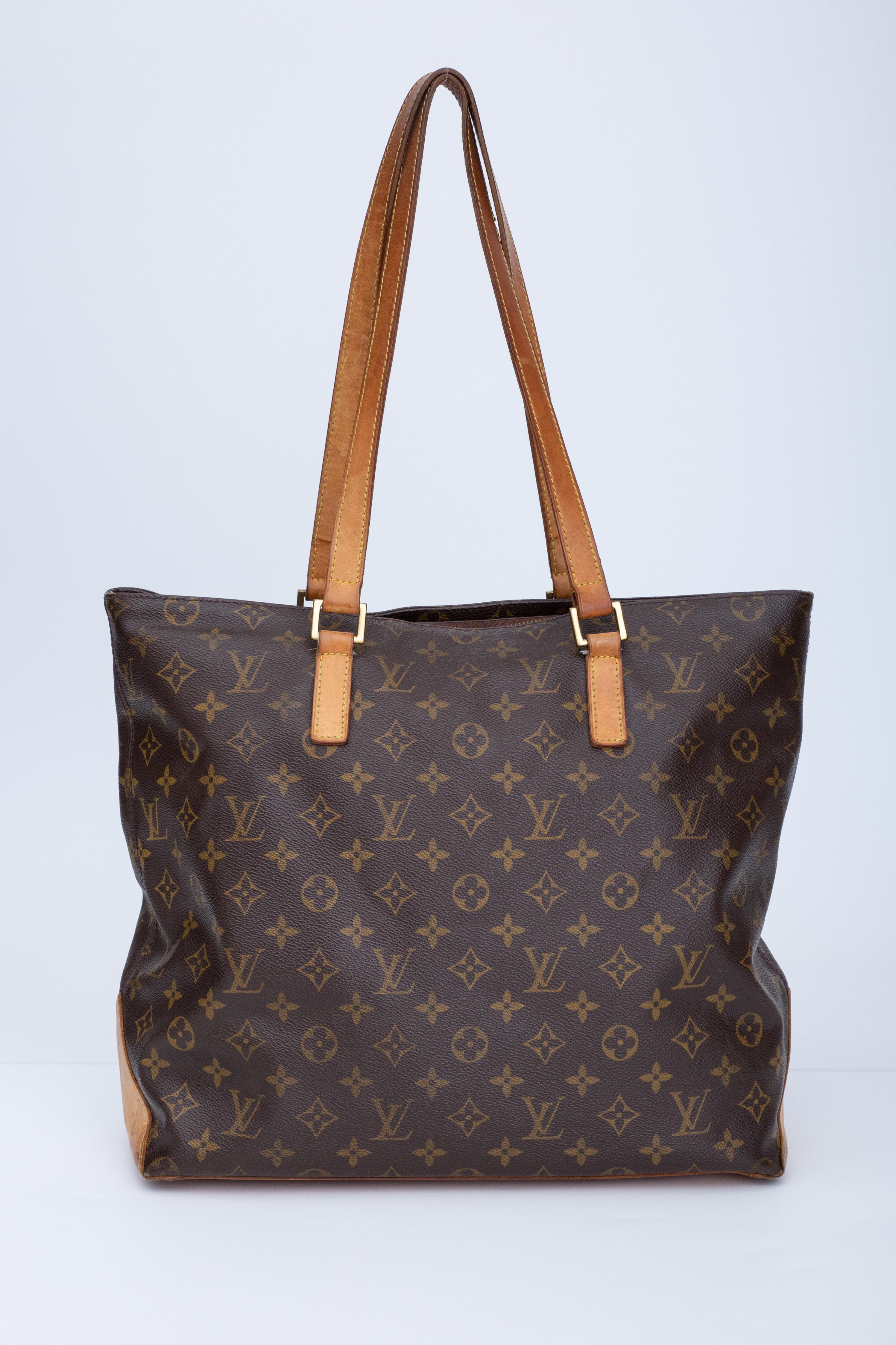 This tote is made of classic Louis Vuitton monogram coated canvas with vachetta leather shoulder straps, a matching base, and polished brass hardware. The top zipper opens the bag to a cocoa brown fabric interior with pockets.

COLOR: