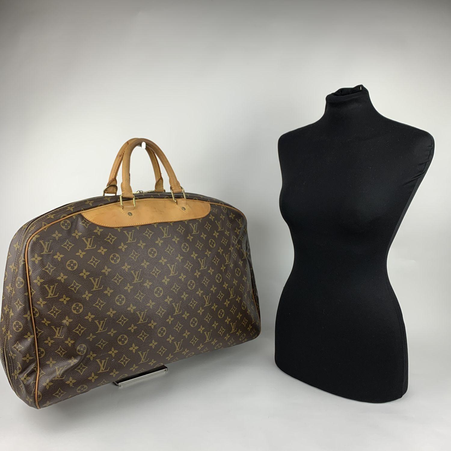 Louis Vuitton 'Alize 1 Poche' travel bag crafted in timeless monogram canvas with genuine leather trim and handles. Wrap around zipper closure. Beige washable lining with 1 side open pocket inside and 2 straps with button closure to hold a hanger.