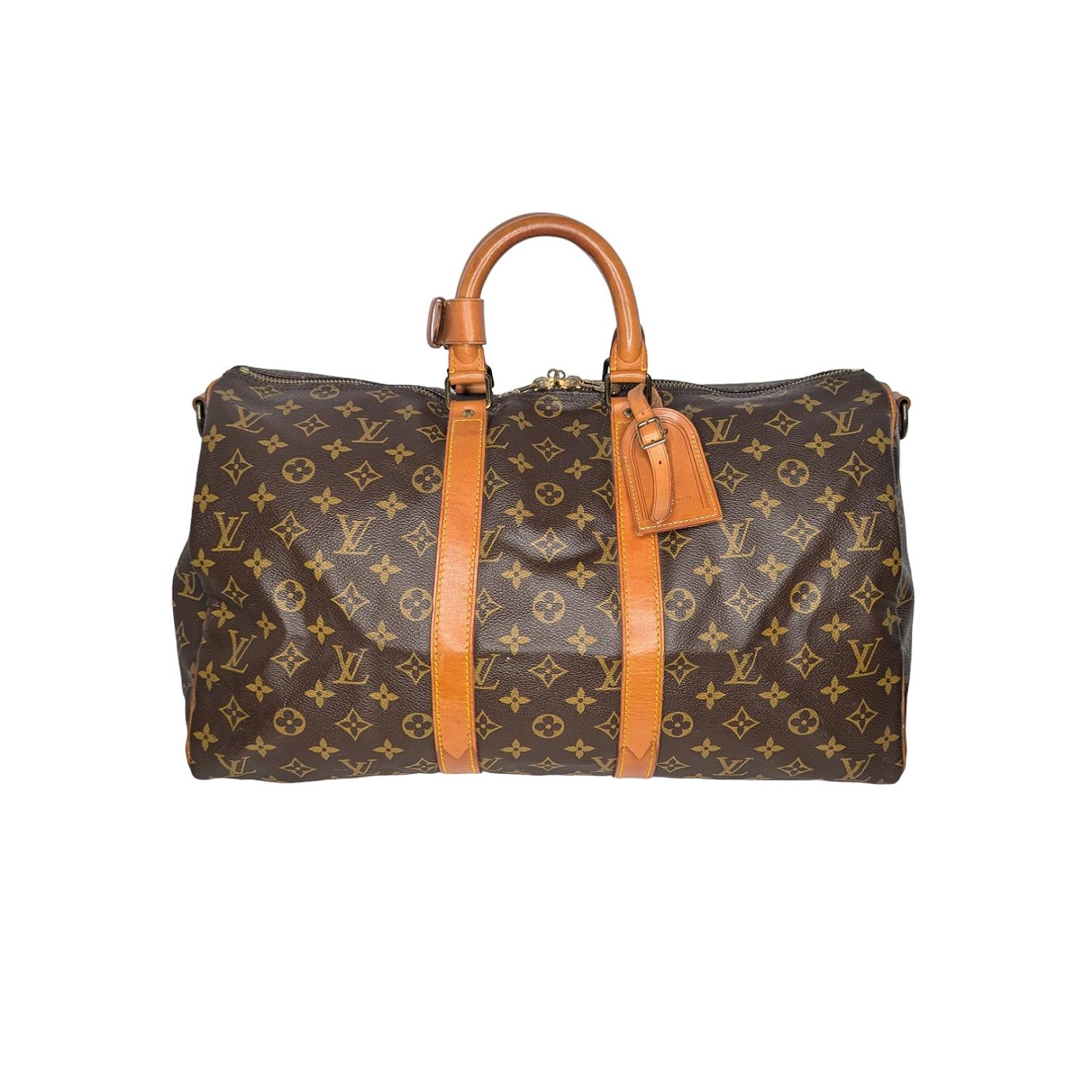 This stylish duffel is crafted of monogram coated canvas with vachetta leather wrap around detailing and rolled top handles with brass hardware. The top zippers open to a cocoa brown fabric interior. Est. Retail $2,440.

Designer: Louis